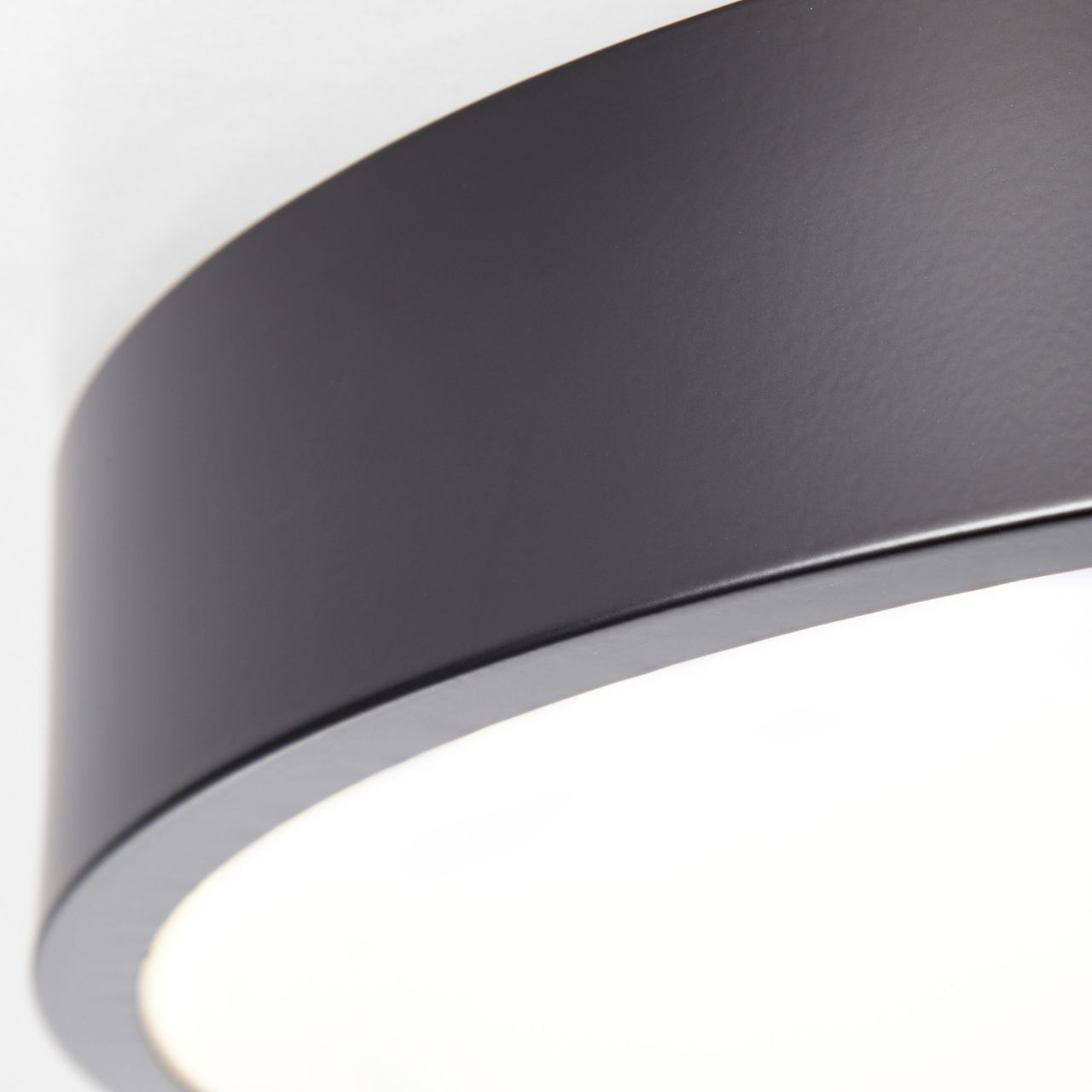 Dunkelgrauer Rand einer Lampe mit weißem Licht darunter.