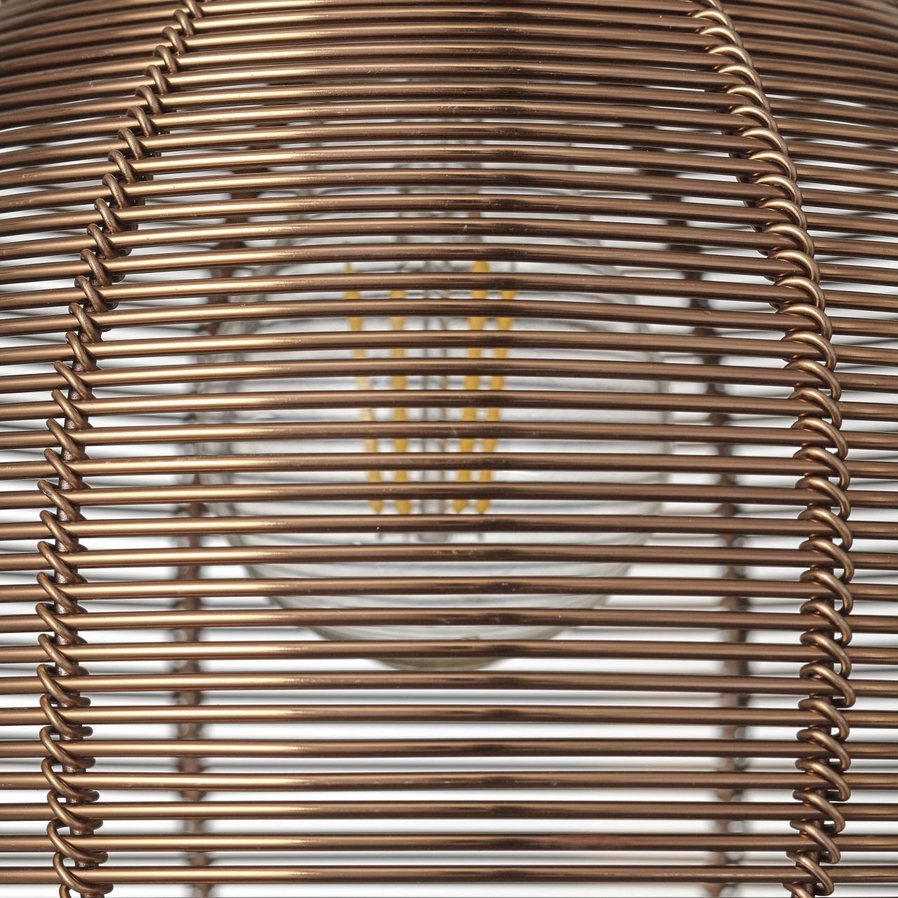 Eine kupferfarbene Lampe mit einem Drahtgeflecht und sichtbarem Glühfaden.
