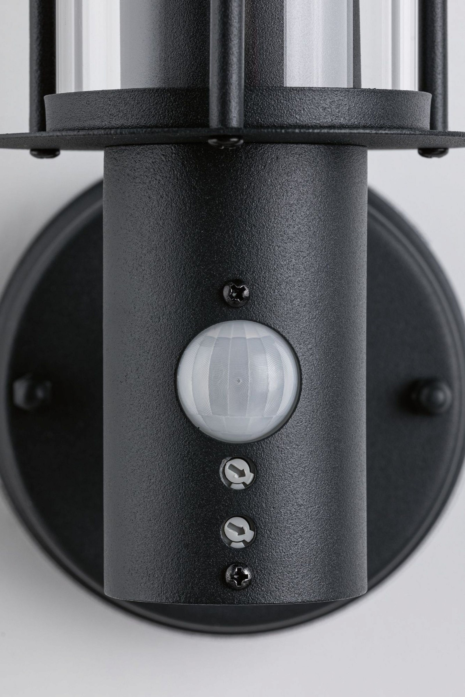 Zbliżenie czarnej oprawy oświetleniowej zewnętrznej z czujnikiem.