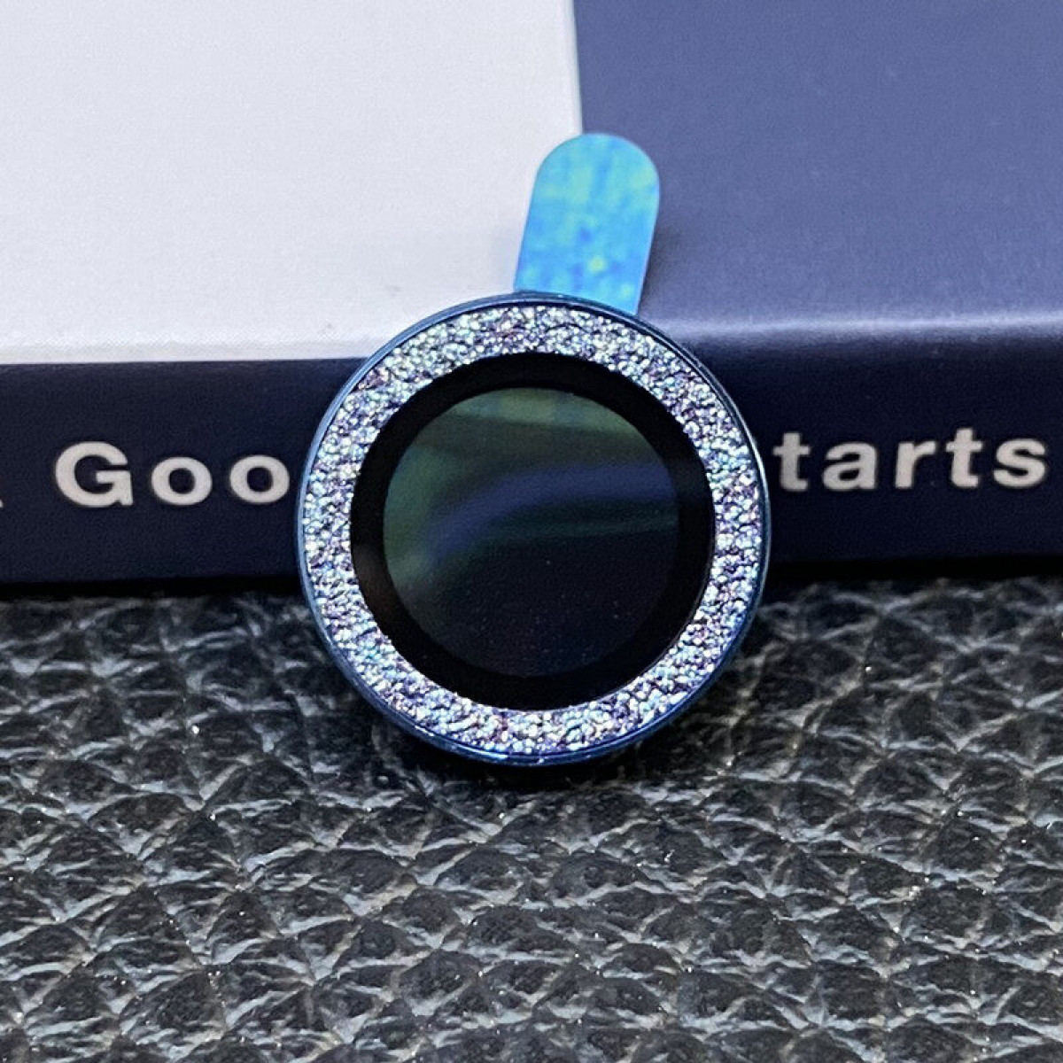 Nahaufnahme einer Telefonlinse mit blauem Ring und funkelnden Akzenten.