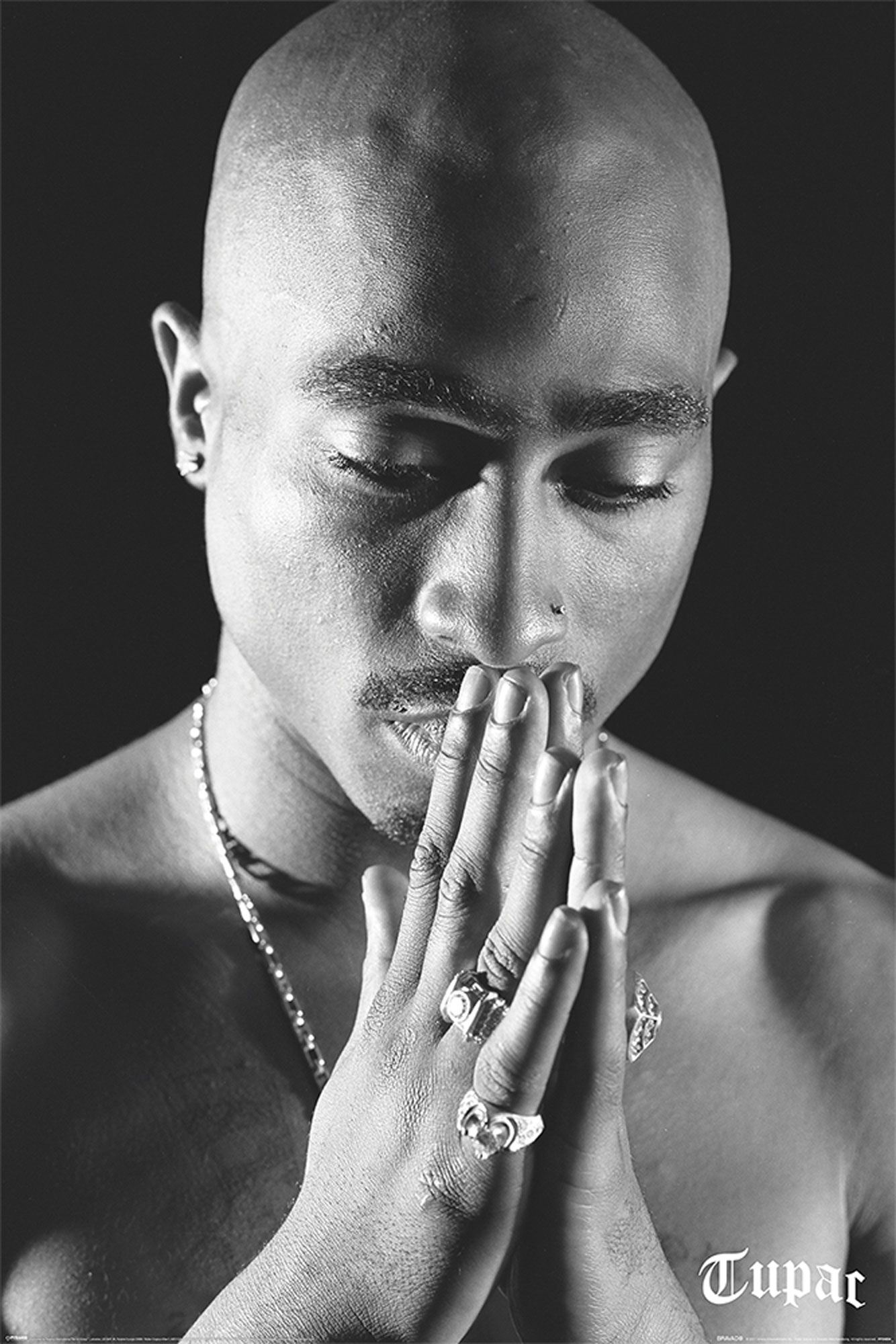 Schwarz-Weiß-Bild von Tupac beim Beten. Hände gefaltet, Ringe sichtbar, dunkler Hintergrund.