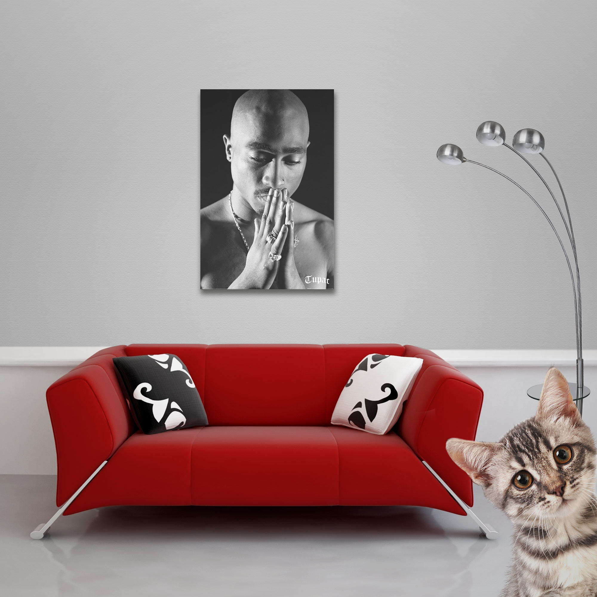 Ein Raum mit rotem Sofa, gerahmtem Bild, Katze und silberner Lampe.