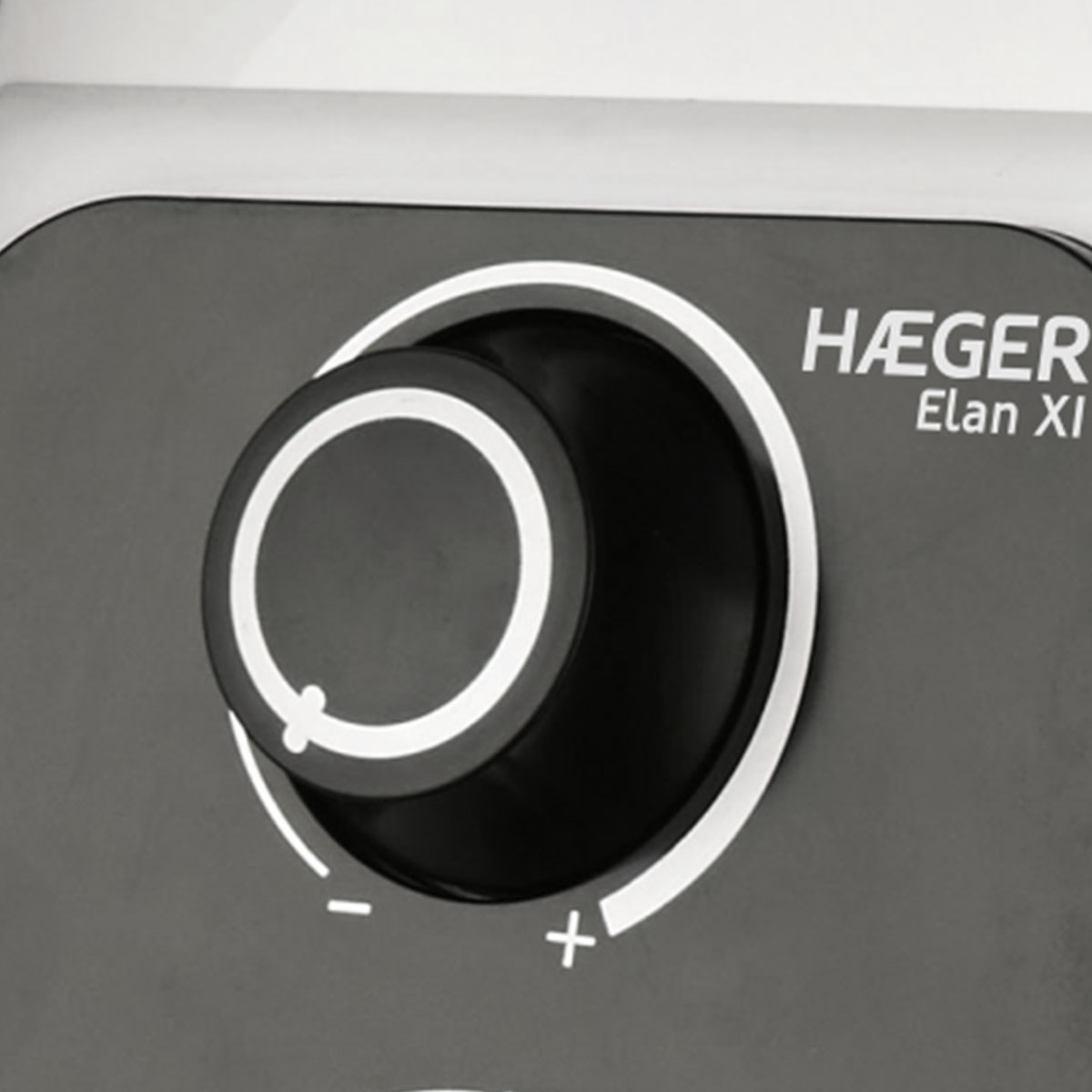 Zbliżenie na czarno-białe pokrętło z symbolami plus i minus.