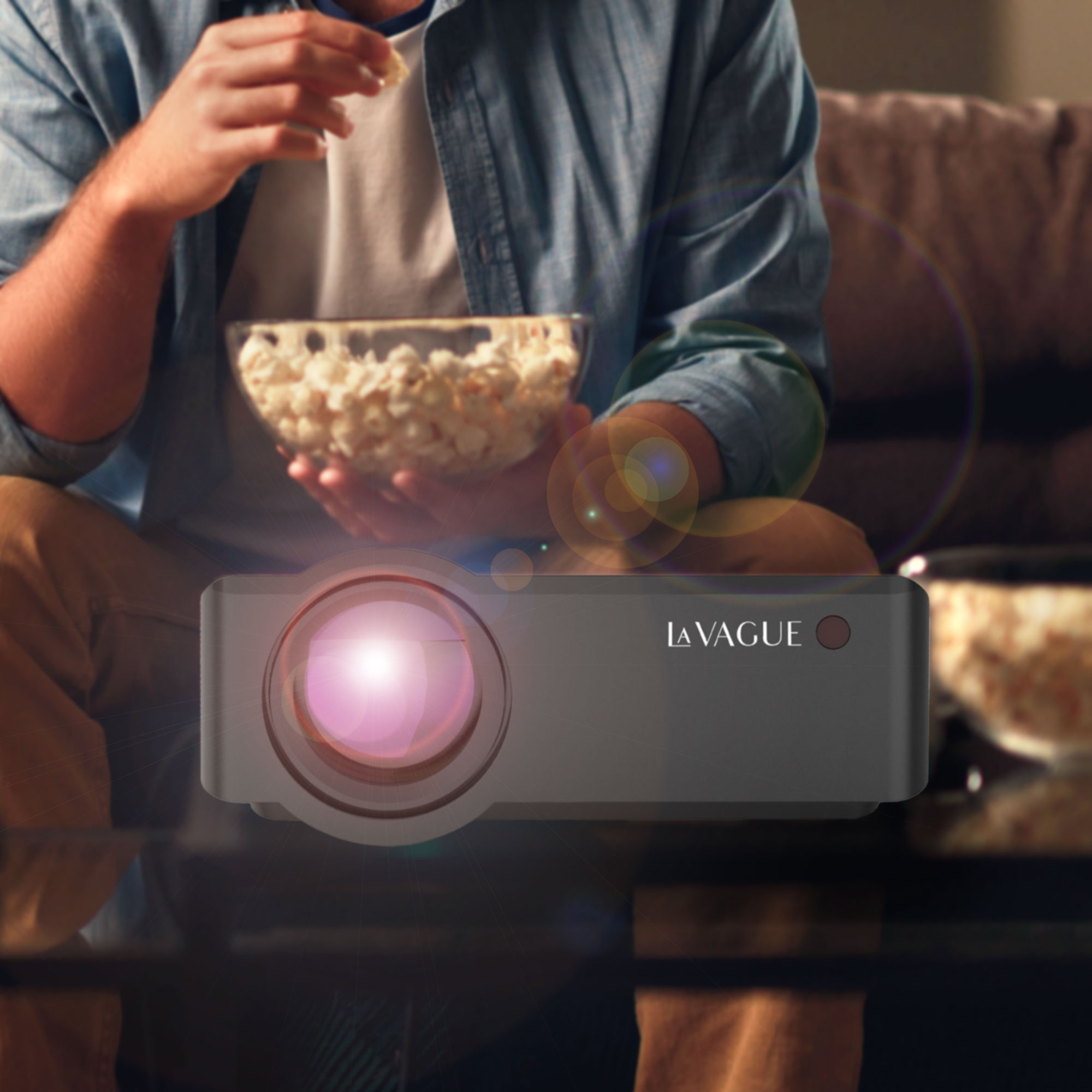 Mann isst Popcorn, schaut Film. Ein Projektor steht im Fokus.