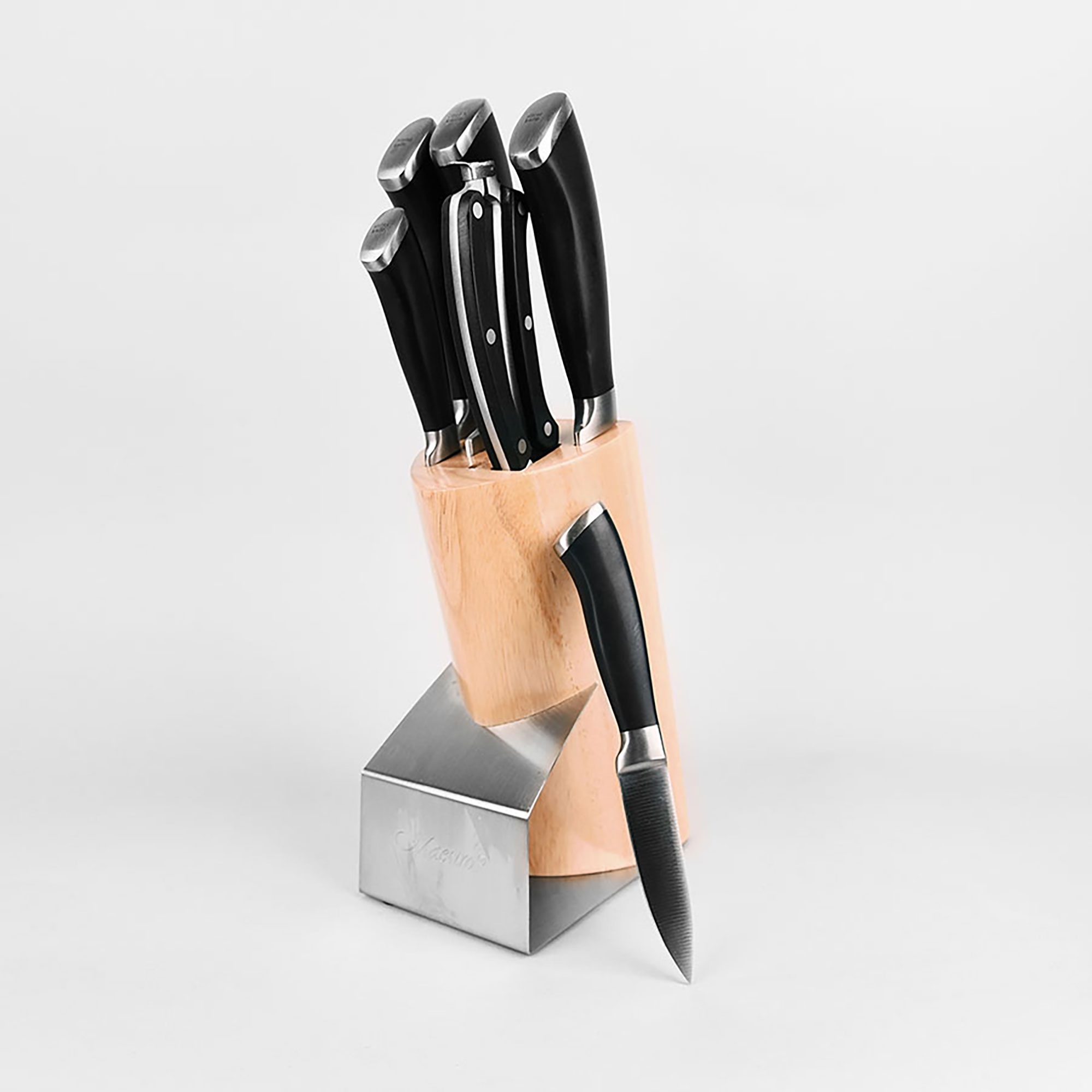 Juego de cuchillos con mango negro en un bloque de madera. Un cuchillo está fuera.