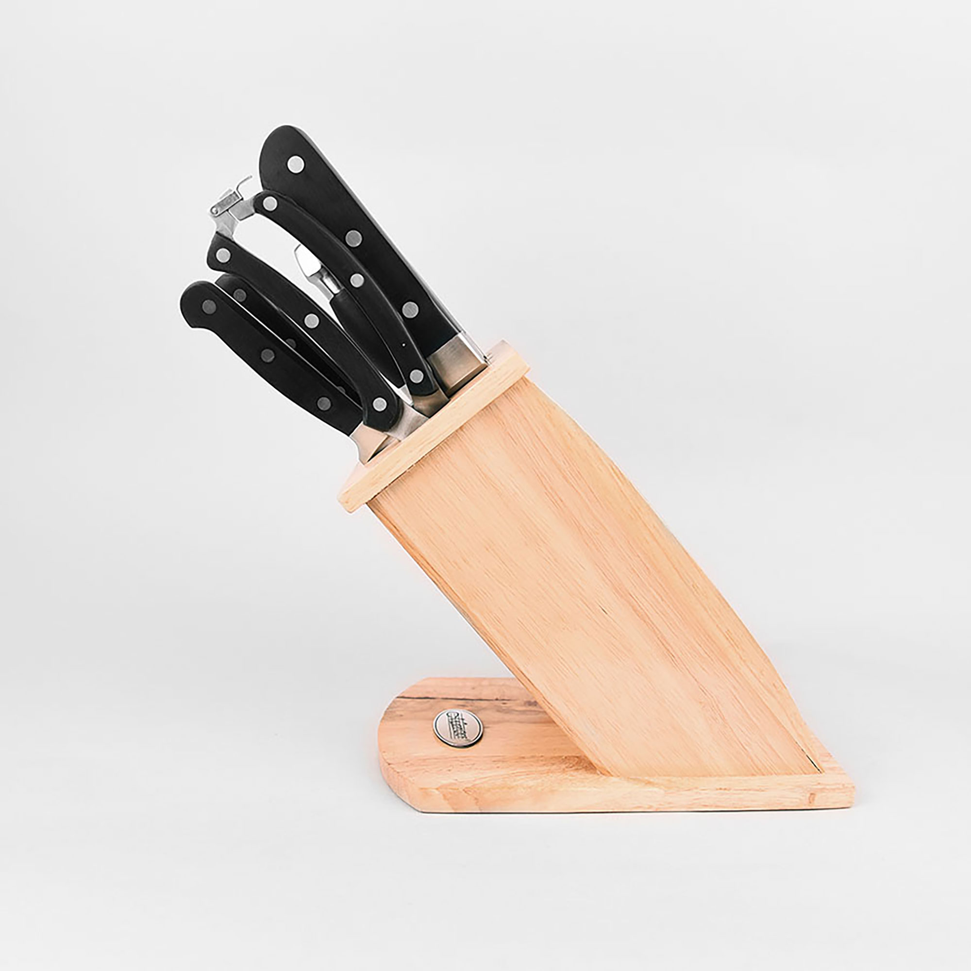 Juego de cuchillos con mangos negros en un bloque de madera, sobre superficie blanca.