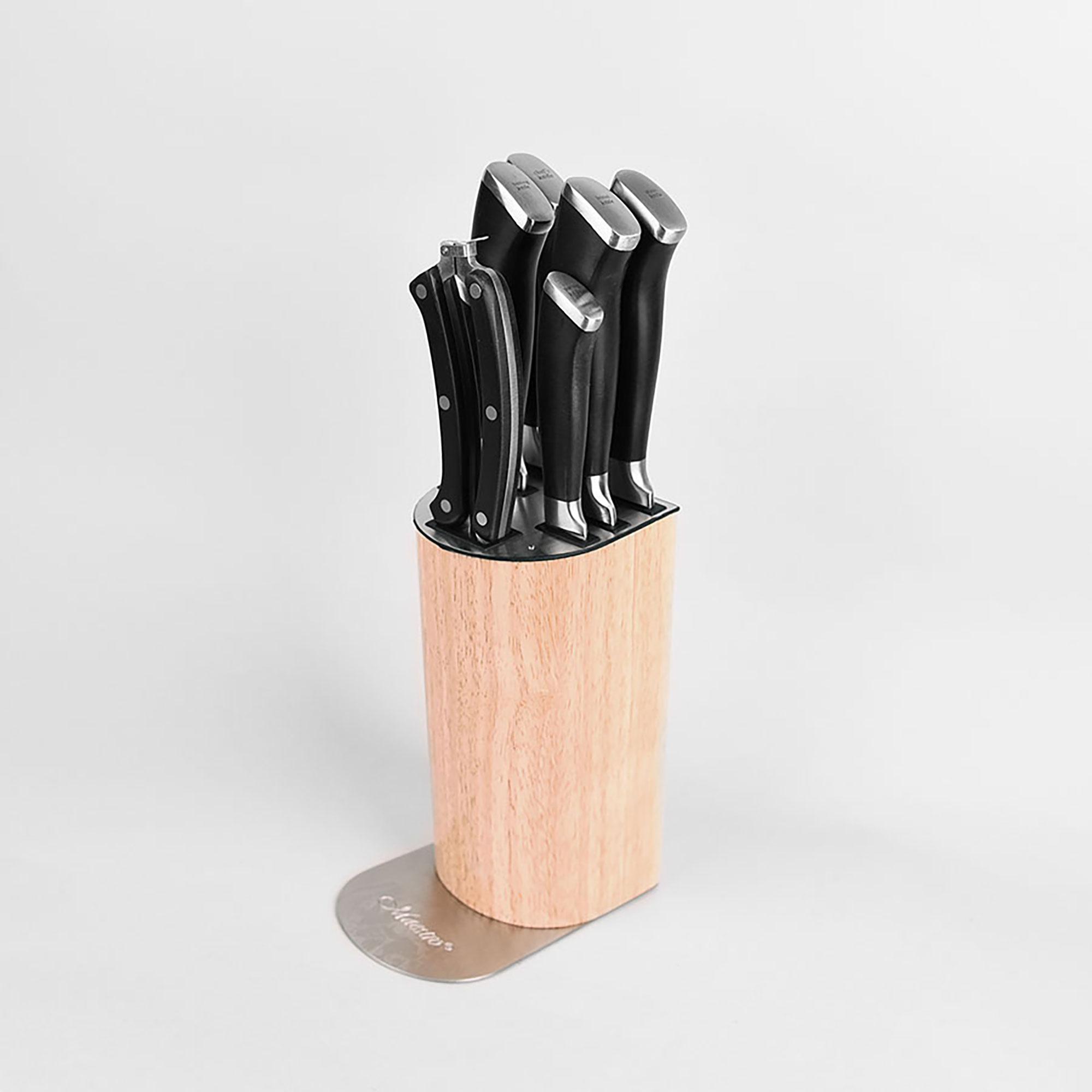Un juego de cuchillos en un bloque de madera. Los cuchillos tienen mangos negros y hojas plateadas.