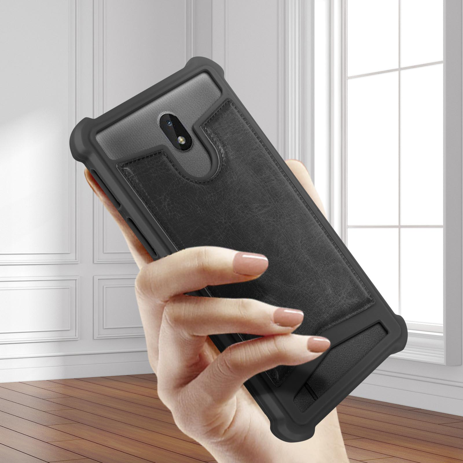 Una mano tiene un telefono con una custodia nera con porta carte. Il telefono è in una stanza.
