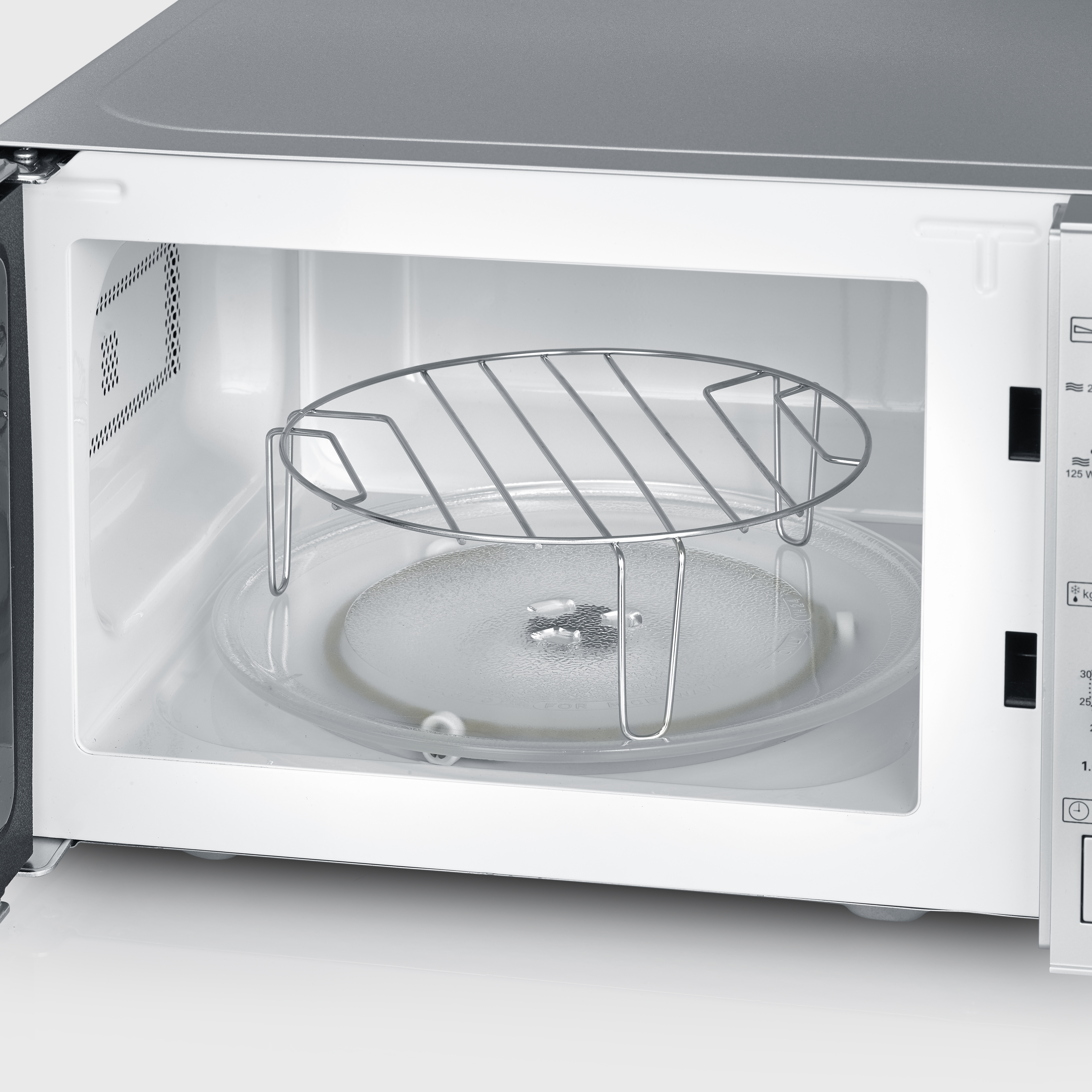 Inside a microwave oven; glass plate and metal rack. White interior, open door.