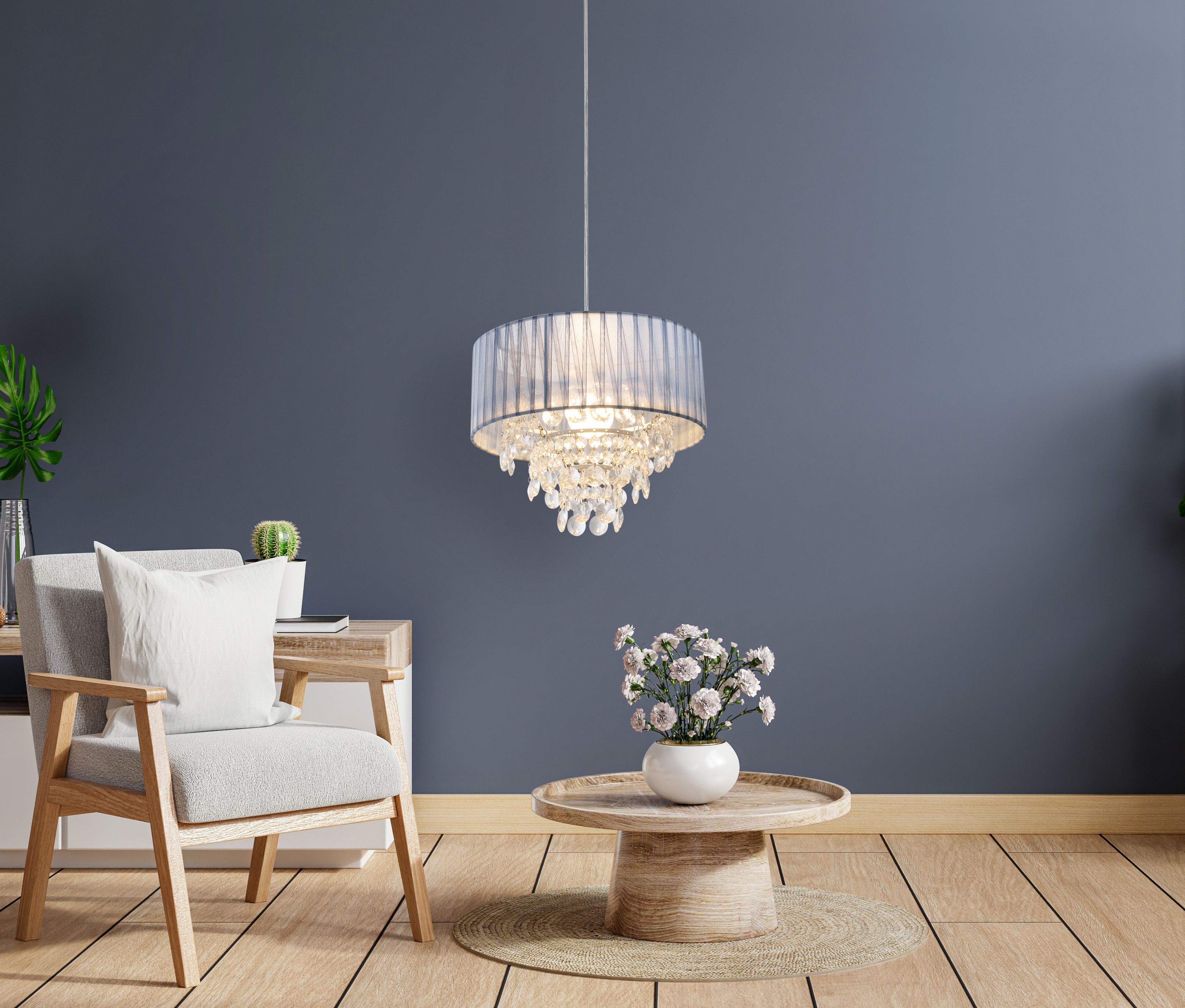 Un salon moderne avec un lustre, une chaise blanche, une table avec des fleurs et un plancher en bois.