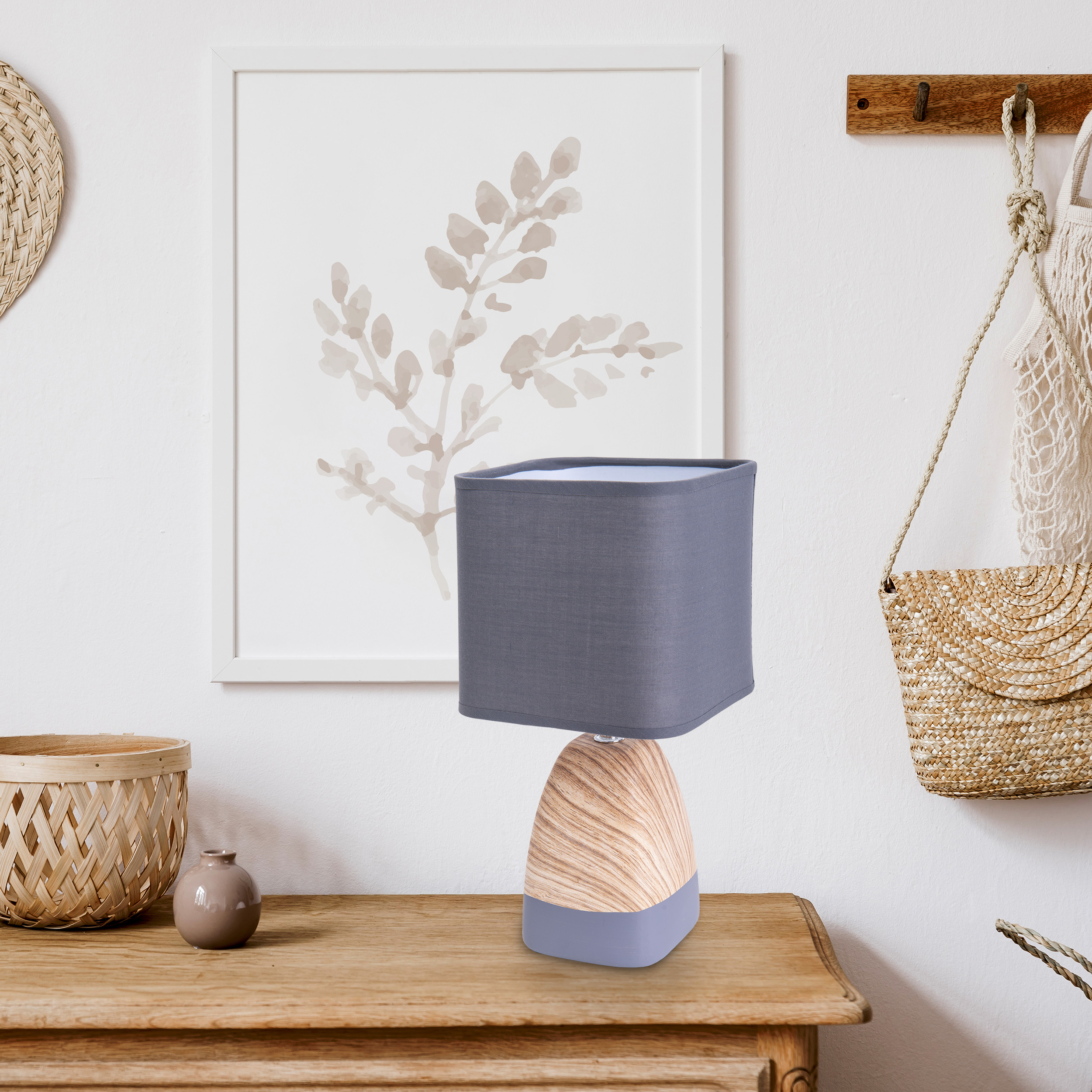 Holztisch mit Lampe, Gemälde und Dekorationsartikeln.