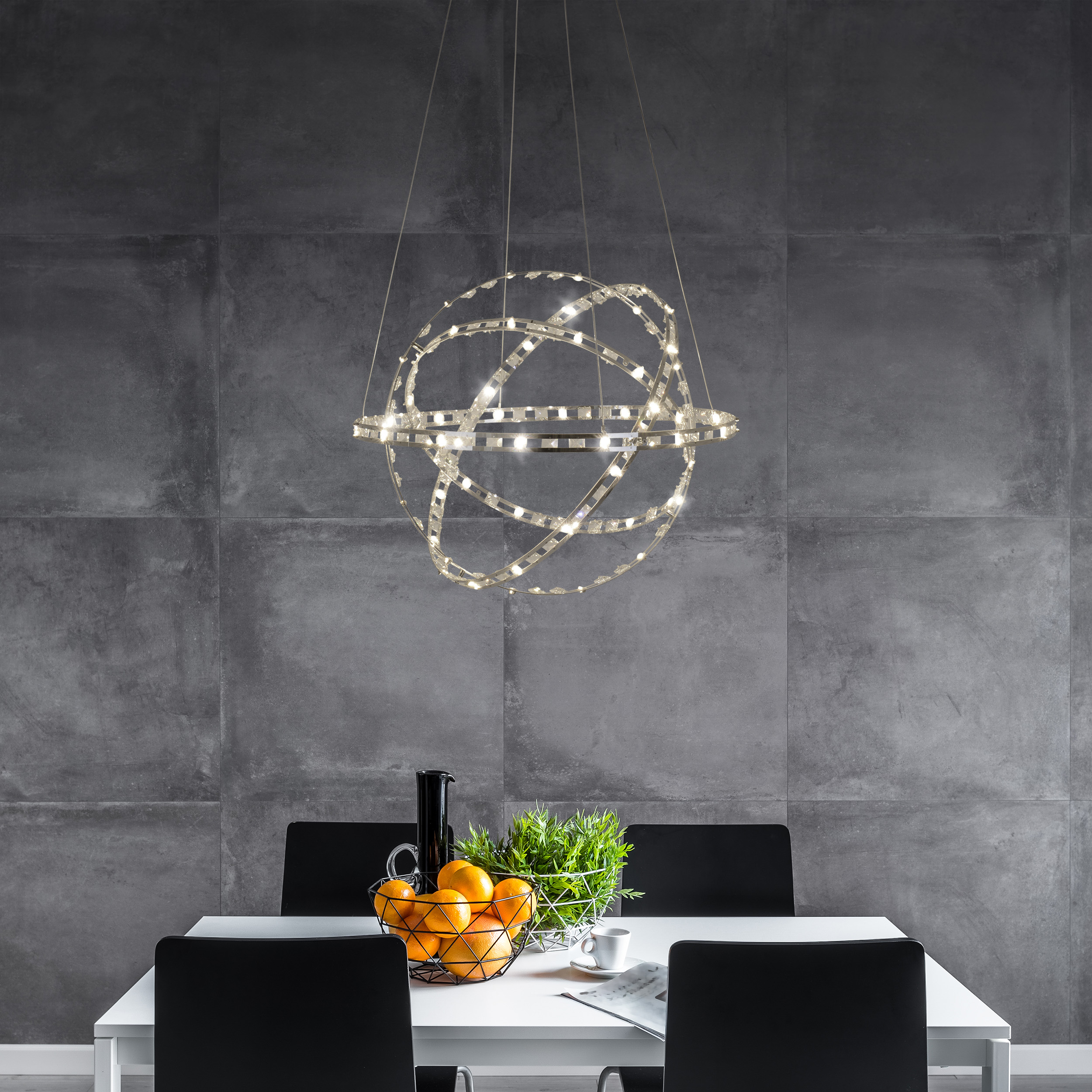 Esszimmer mit weißem Tisch, schwarzen Stühlen und dekorativem Kronleuchter.