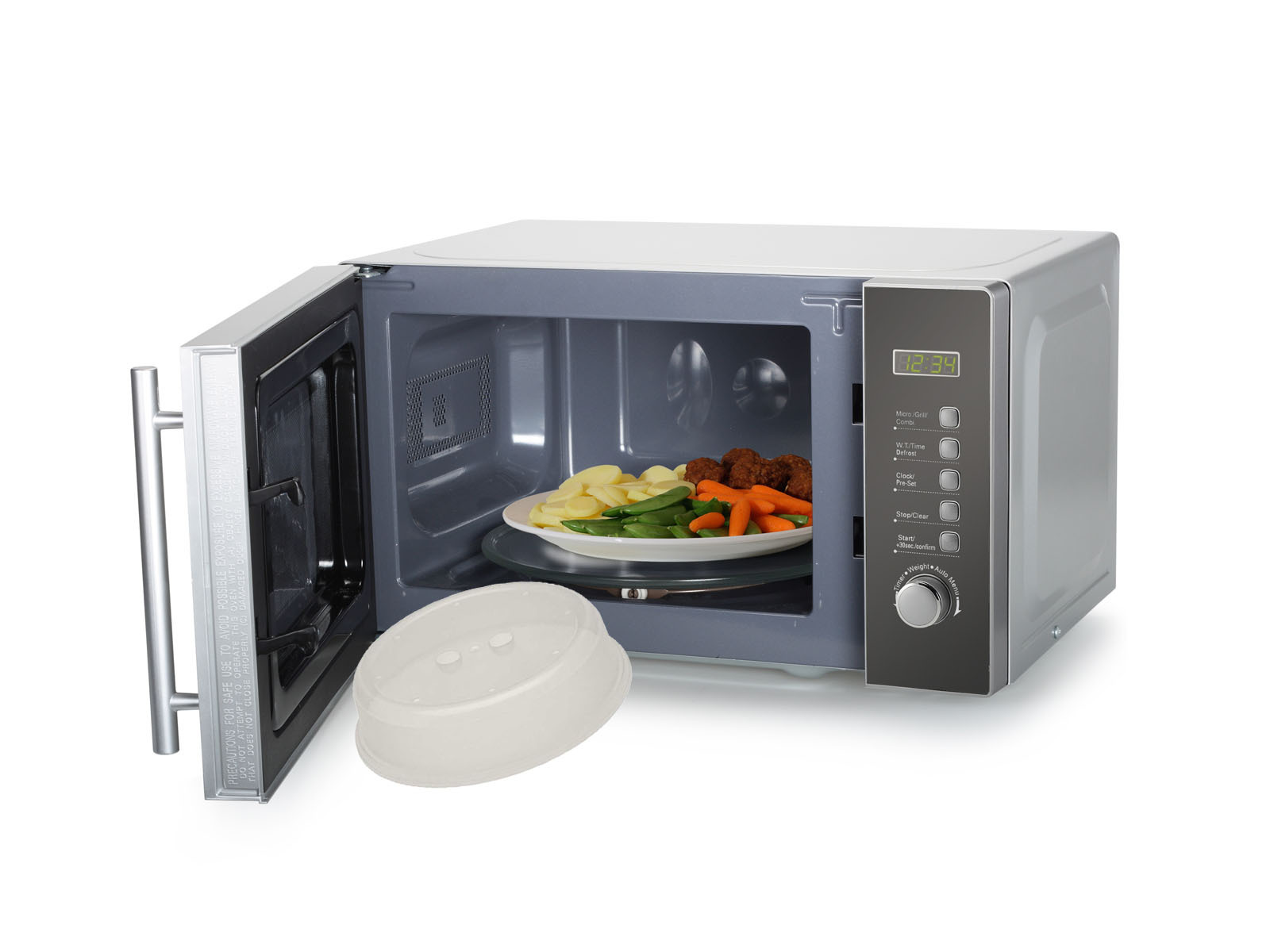 Mikrowelle mit offener Tür, Teller mit Essen und Deckel. Weißer Hintergrund.