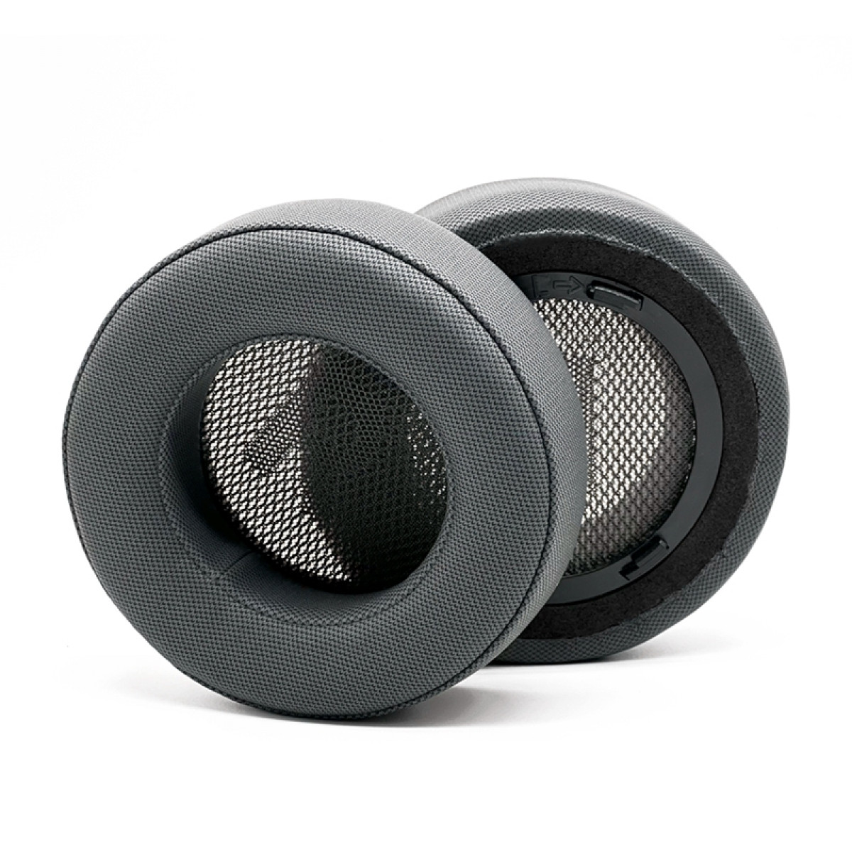 Dos almohadillas grises para auriculares, redondas, con malla interior, sobre fondo blanco.
