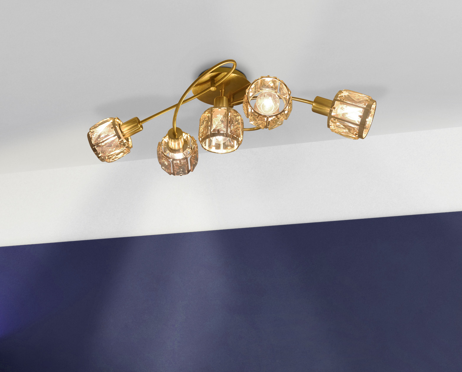 Deckenleuchte mit fünf kristallbedeckten Lampen, Gold-Finish, vor weiß-blauem Hintergrund.