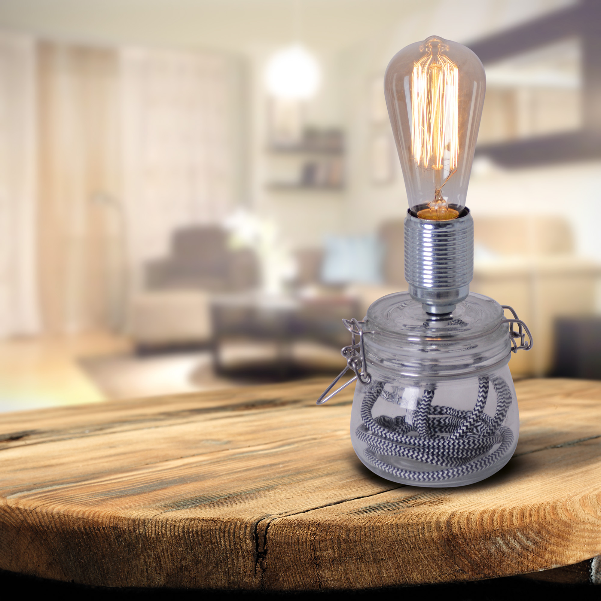 Eine Glühbirnenlampe steht auf einem Holztisch. Ein verschwommenes Wohnzimmer im Hintergrund.