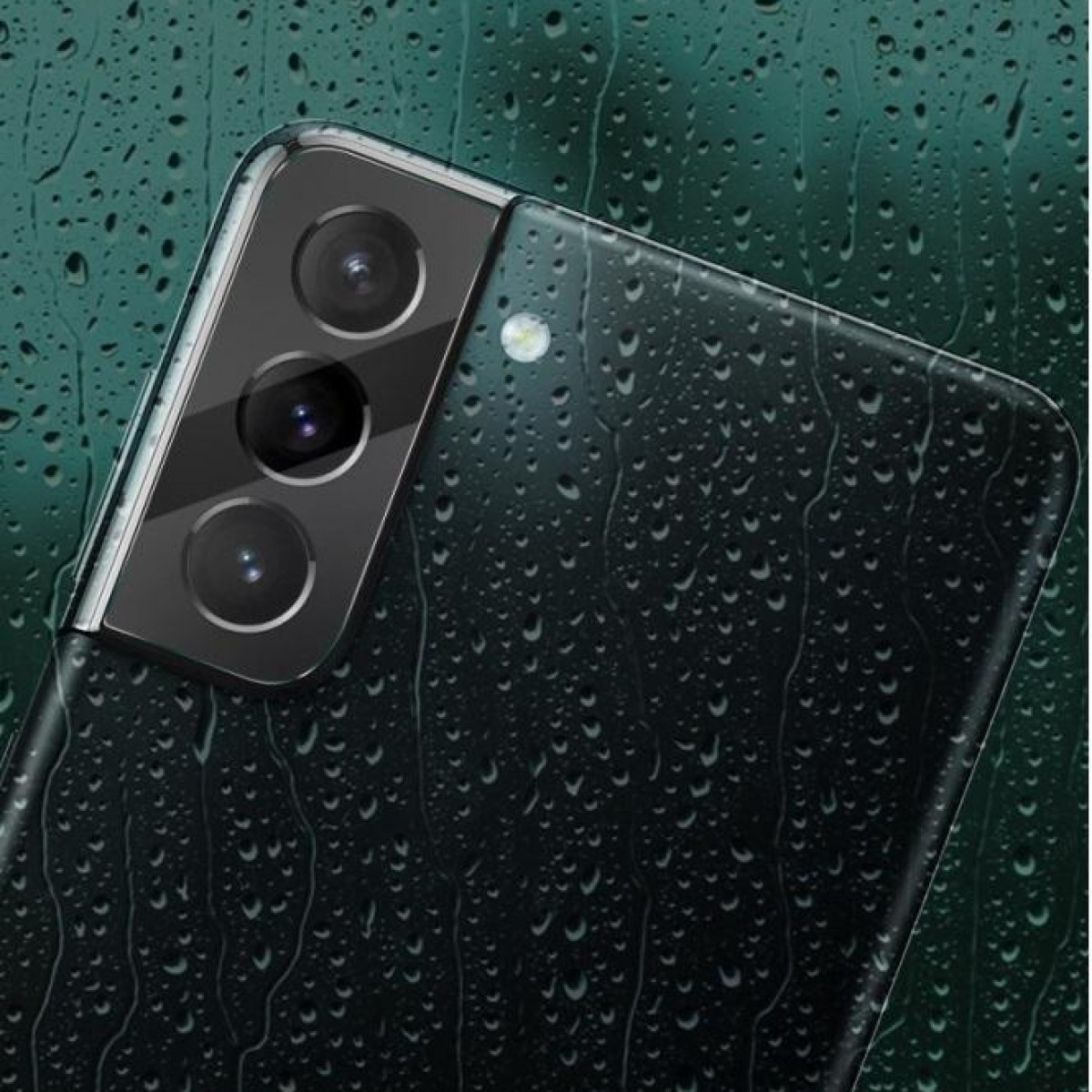 Nahaufnahme eines Smartphones mit Dreifach-Kamera auf einer wasserbedeckten Oberfläche.