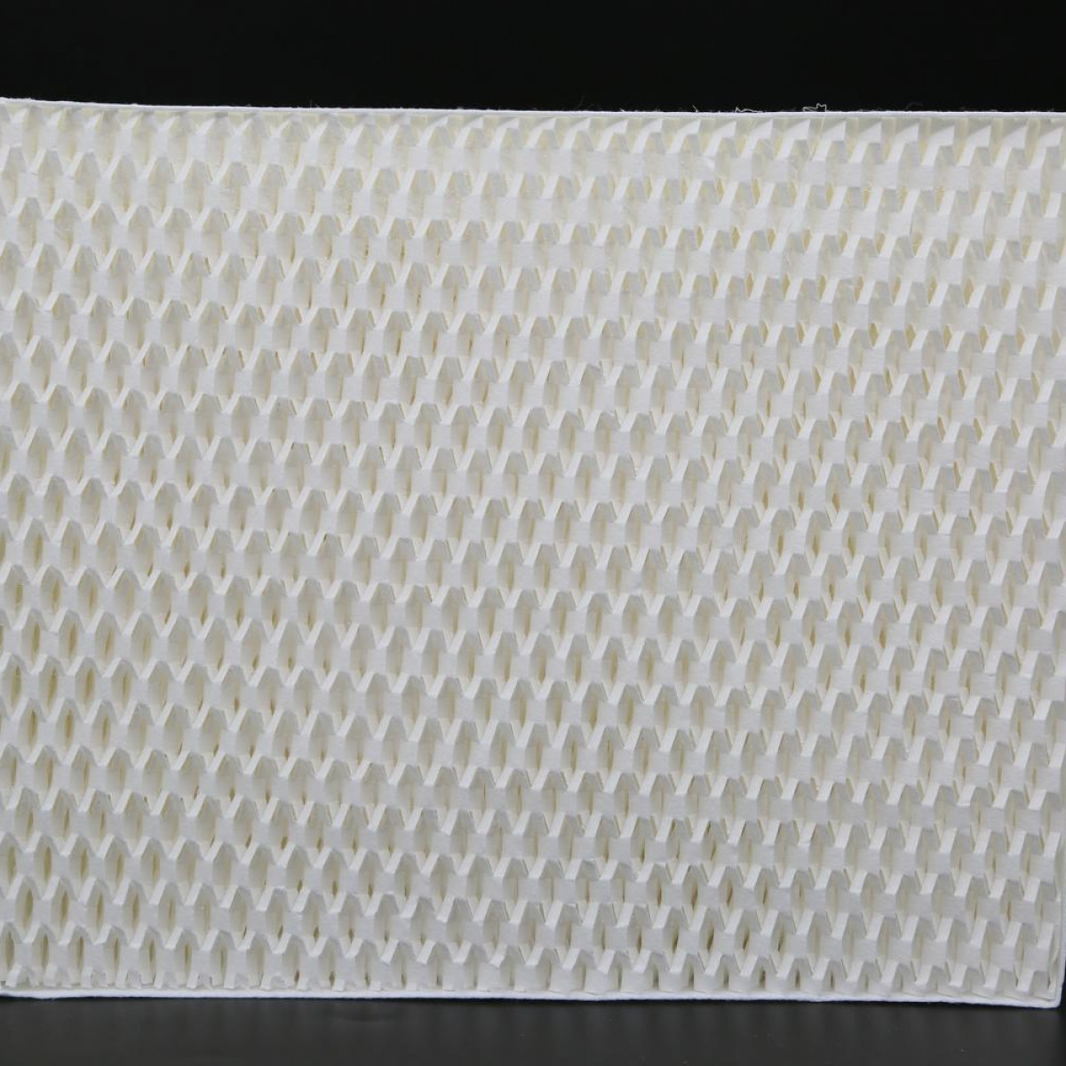 Zbliżenie białego filtra powietrza o wzorze plastra miodu.