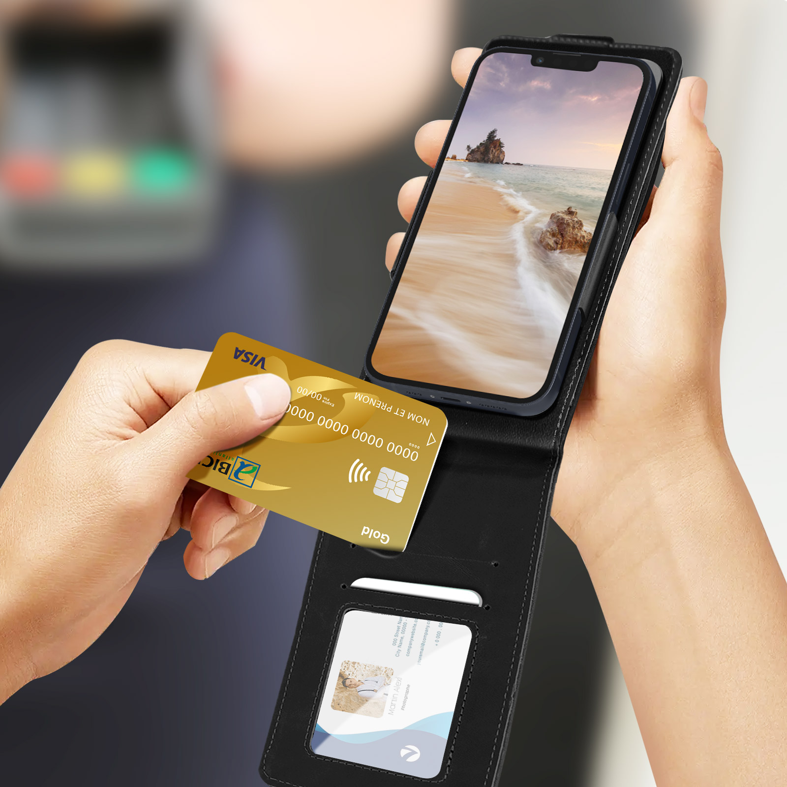 Una mano che tiene una carta di credito d'oro accanto a un telefono in una custodia a portafoglio nera.