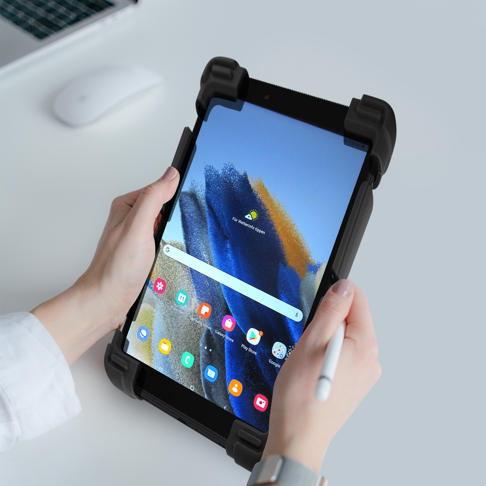 Eine Person hält ein Tablet in einer schwarzen Schutzhülle mit Stift.