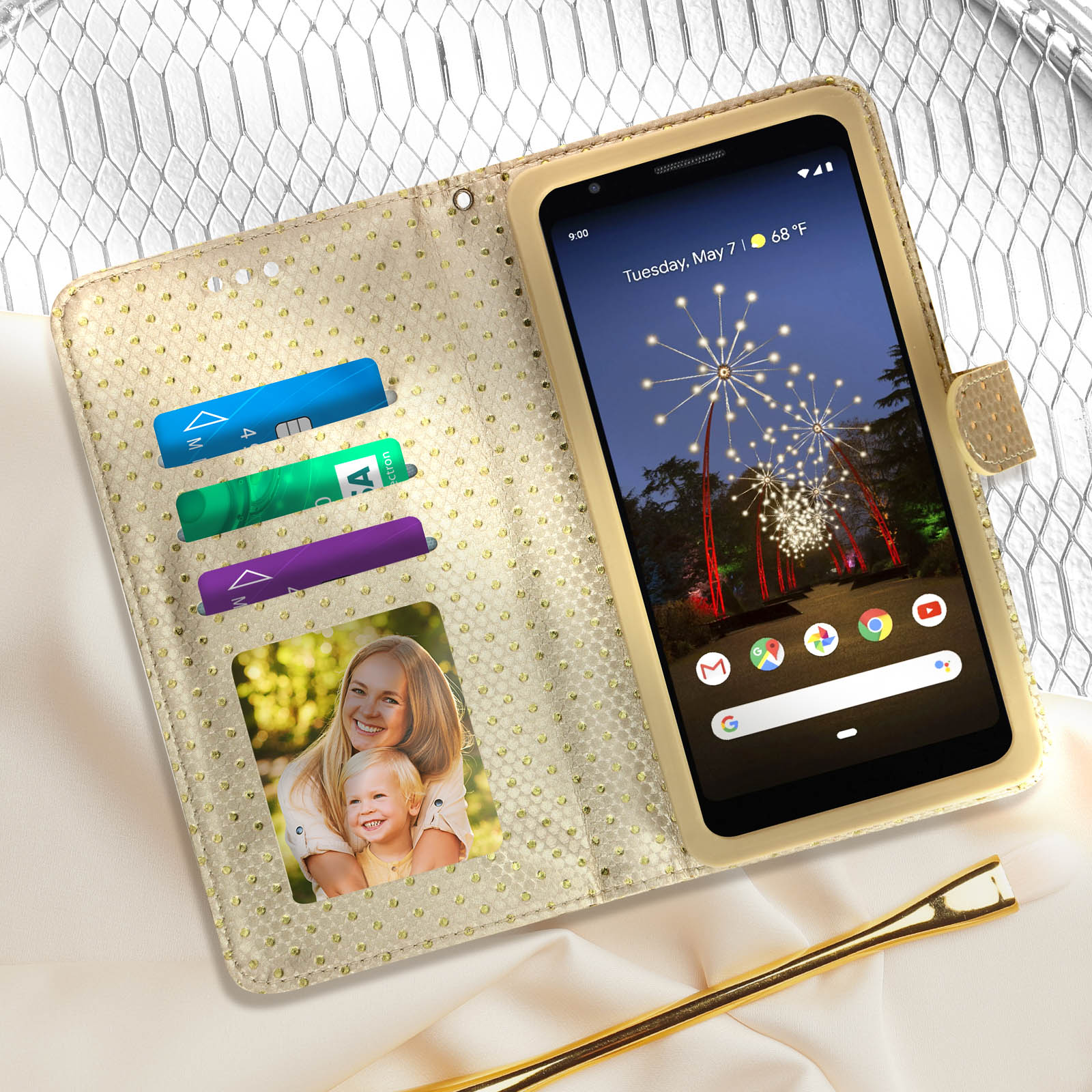 Custodia telefono aperta con carte e foto. Telefono mostra fuochi d'artificio. Colore oro.