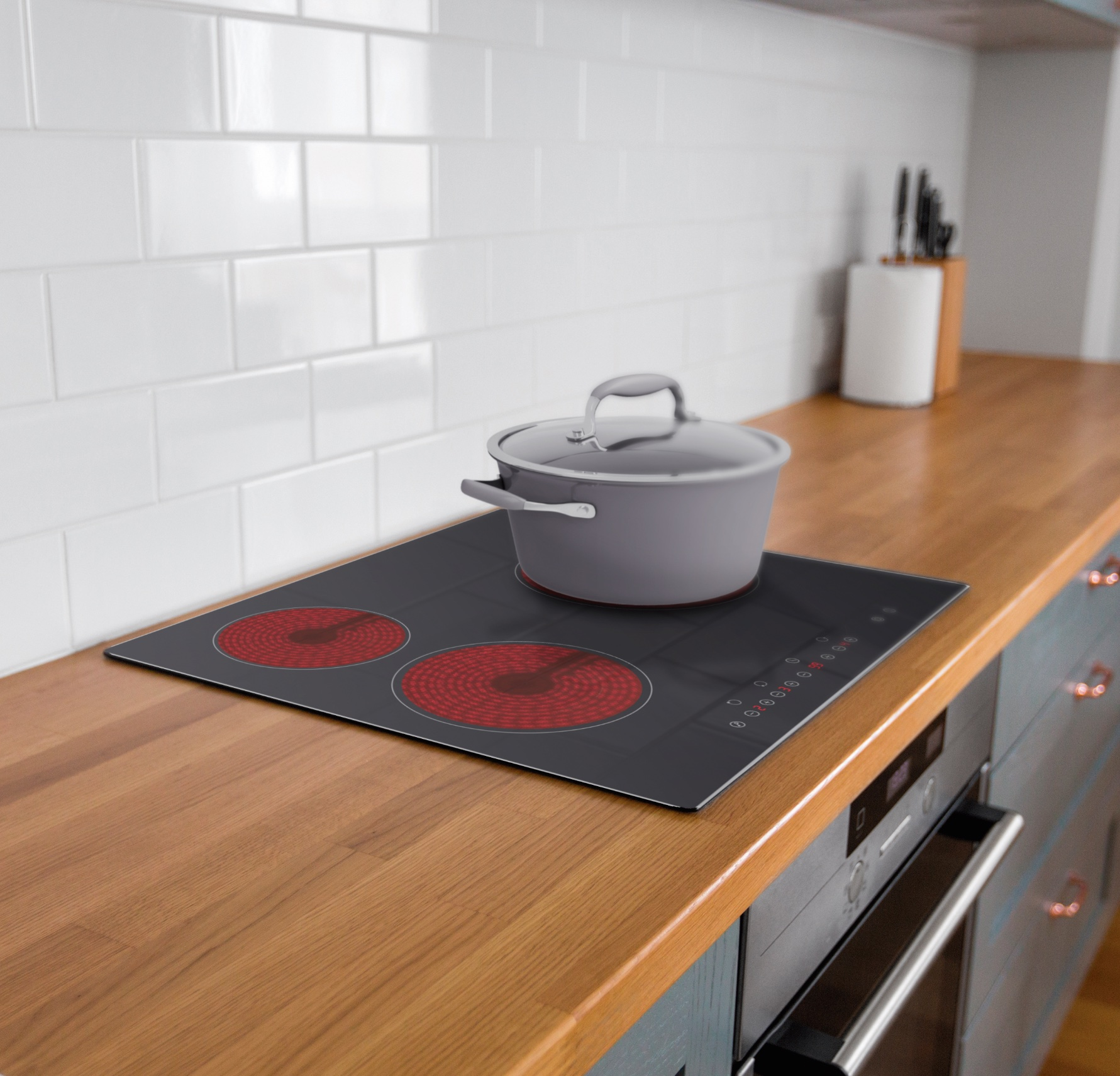 Una olla gris con tapa está sobre una cocina eléctrica negra con dos elementos calefactores rojos. Encimera de madera.