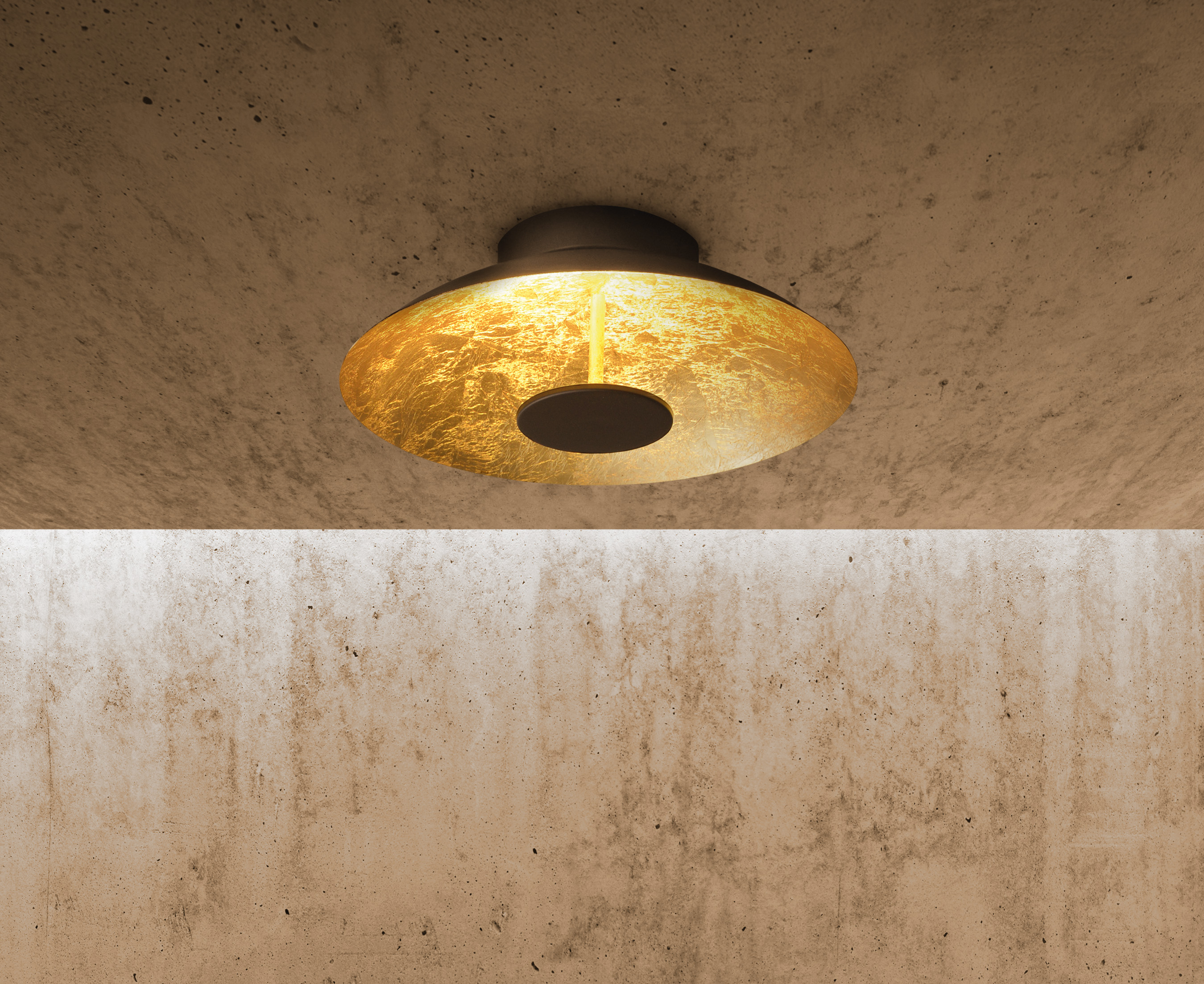 Goldene Deckenlampe mit rundem Design, an einer strukturierten Betondecke befestigt.