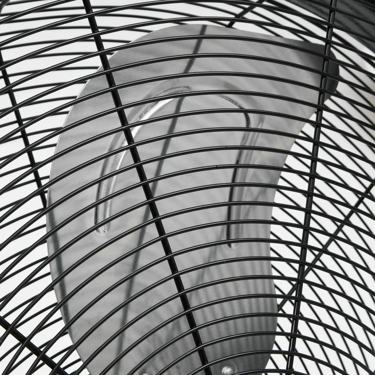 Nahaufnahme eines schwarzen Ventilators mit gewölbtem Metallschutz und schwarzem Drahtgitterdesign.