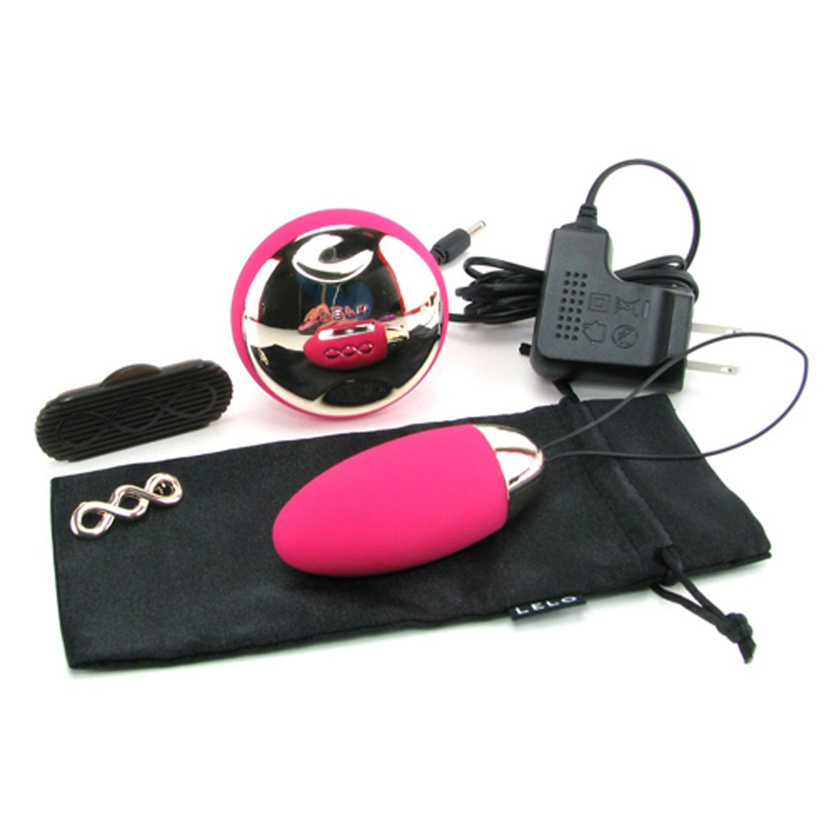 Un vibrador rosa, una esfera plateada y accesorios con una bolsa negra, sobre un fondo blanco.