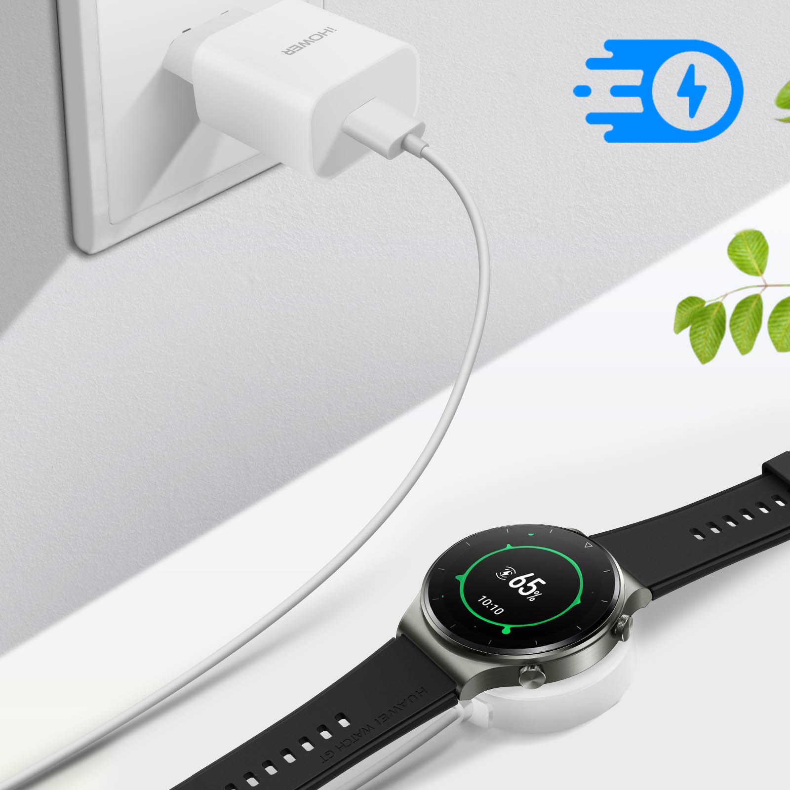 Un caricabatterie bianco è collegato al muro. Uno smartwatch su una base di ricarica mostra il 65% di carica.