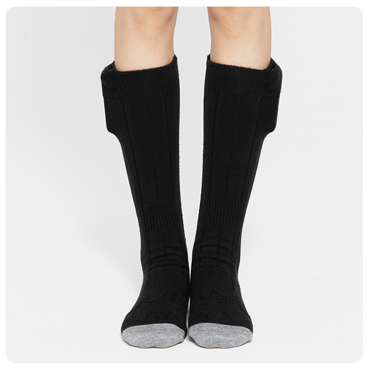 Zwei Beine mit schwarzen Socken und grauen Zehen, auf Weiß.