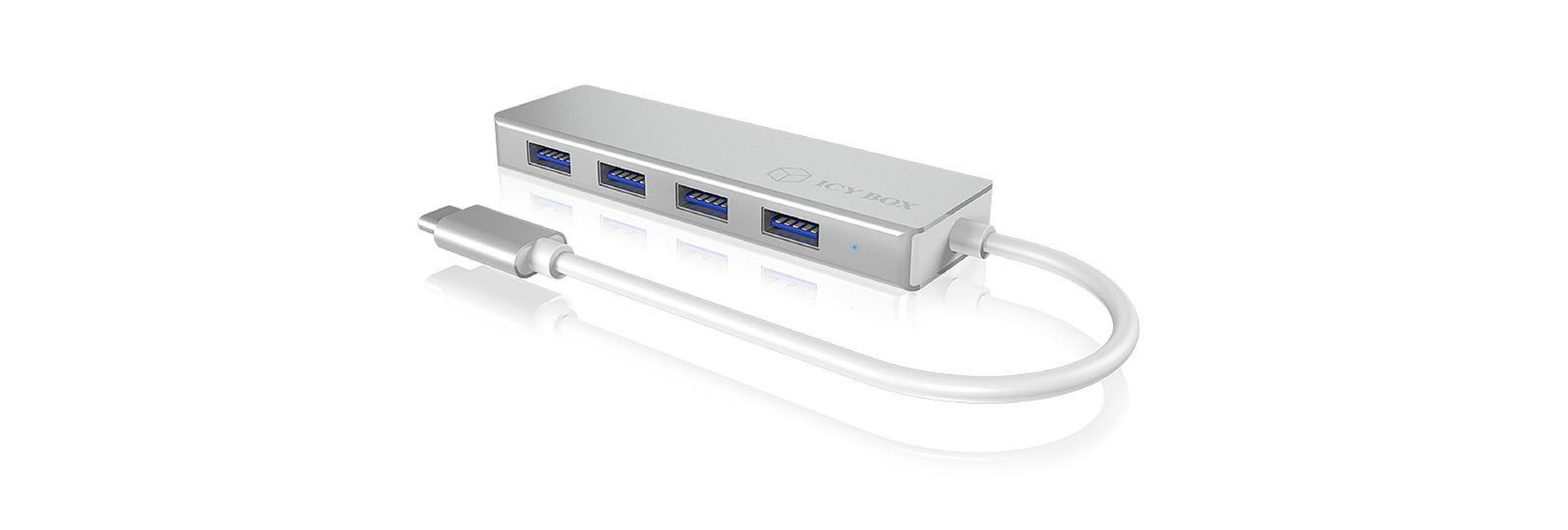 Hub USB argenté avec quatre ports et connecté à un câble blanc. Fond blanc.