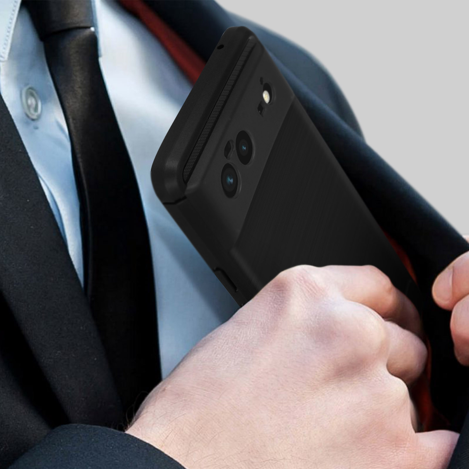 Main dans une poche de costume tenant une coque de téléphone noire.