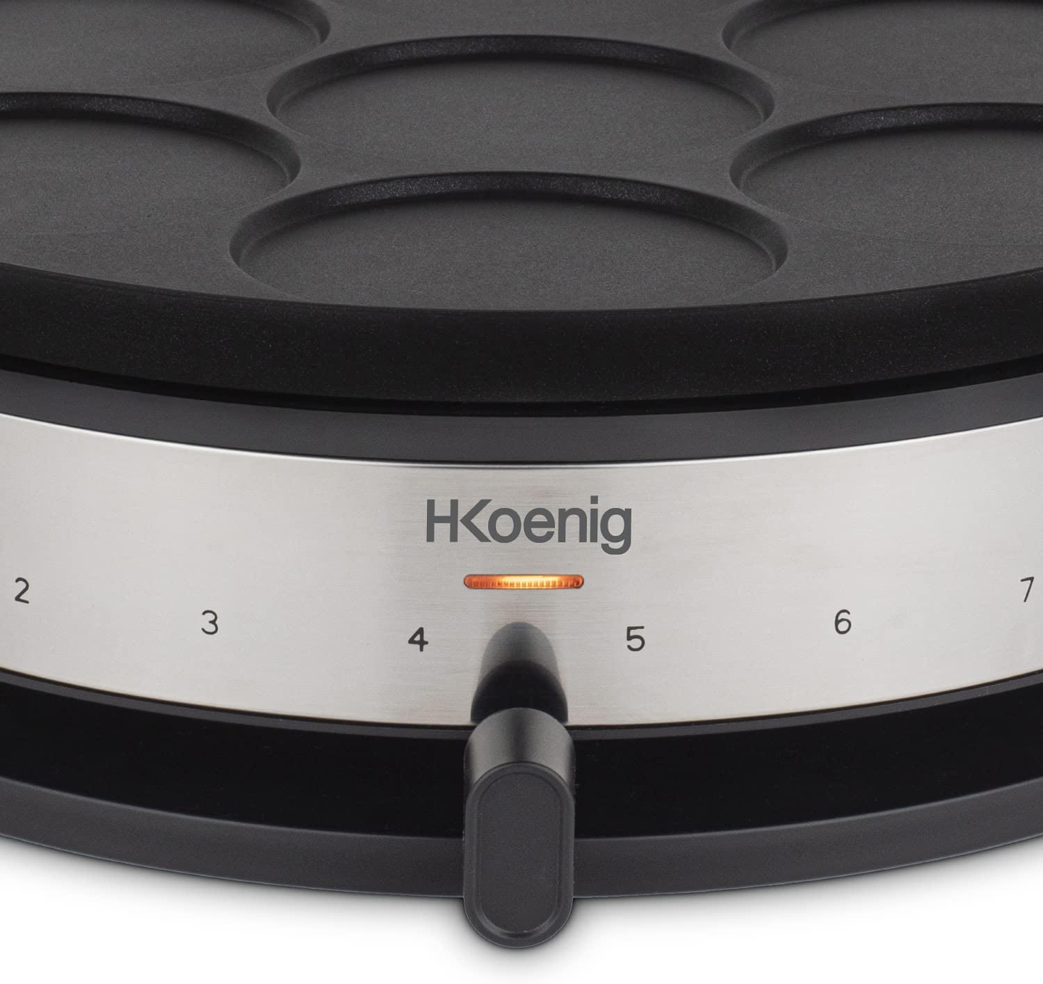 Zbliżenie czarnej gofrownicy ze srebrnym pokrętłem. Pokrętło jest ustawione na numer 4.