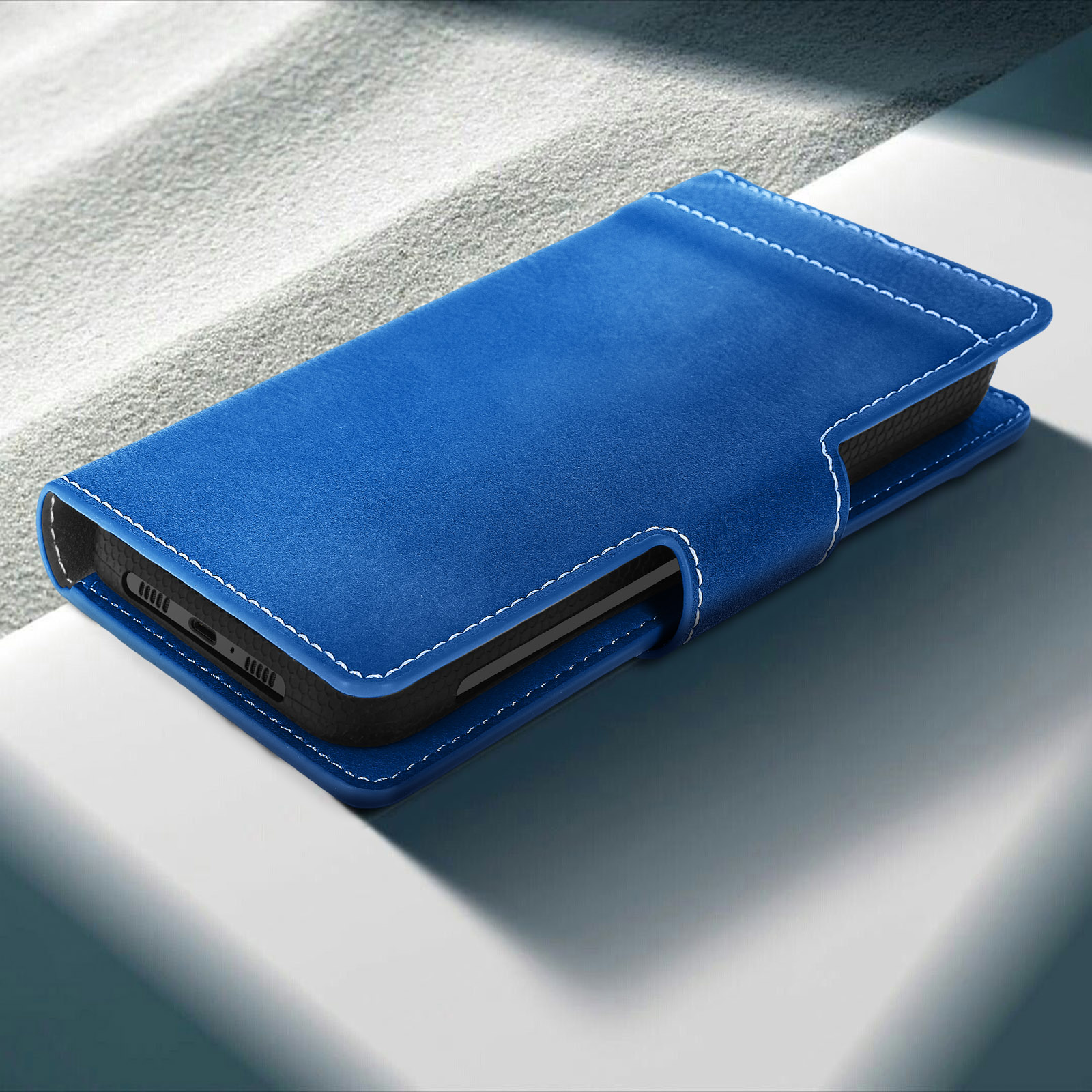 Blaue Handyhülle mit Telefon. Auf weißer Oberfläche. Die Hülle ist geschlossen.