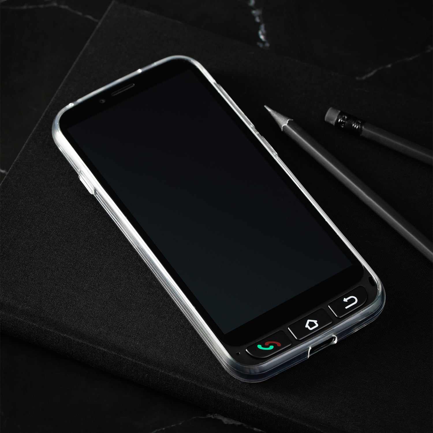 Un smartphone negro sobre una superficie oscura con un lápiz, diseño elegante con botones.
