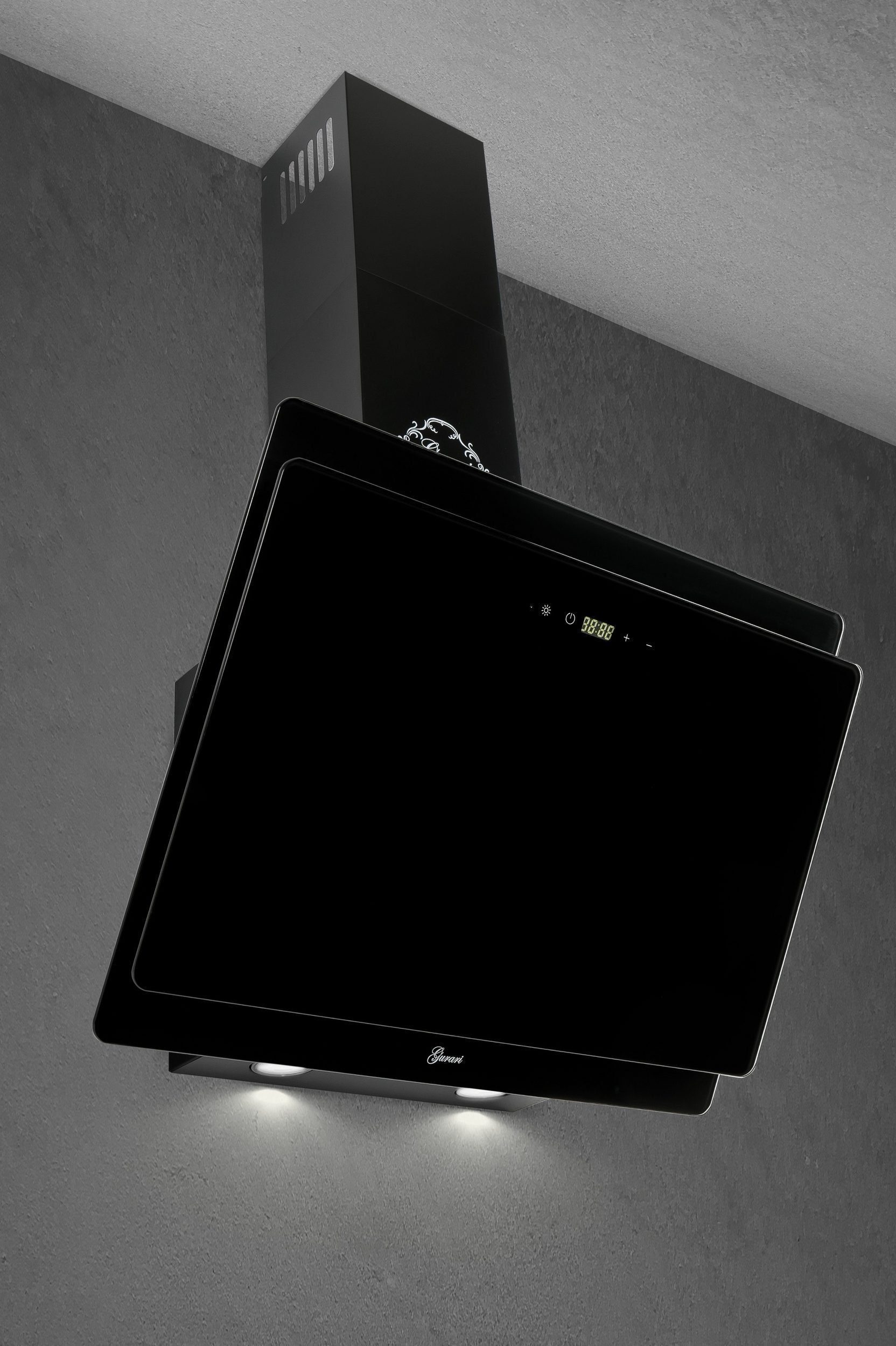 Eine schwarze Dunstabzugshaube an einer grauen Wand. Sie hat eine digitale Anzeige und zwei Lichter darunter.