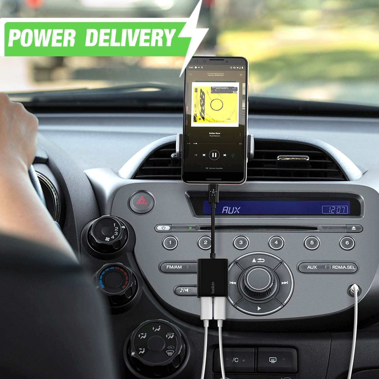 Un telefono in carica in auto, collegato a un adattatore. Il testo recita "POWER DELIVERY".
