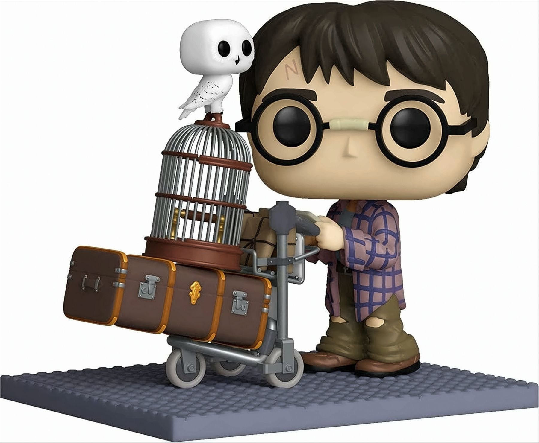 Statuetta di Harry Potter con gufo, carrello portabagagli e bagagli su base grigia.