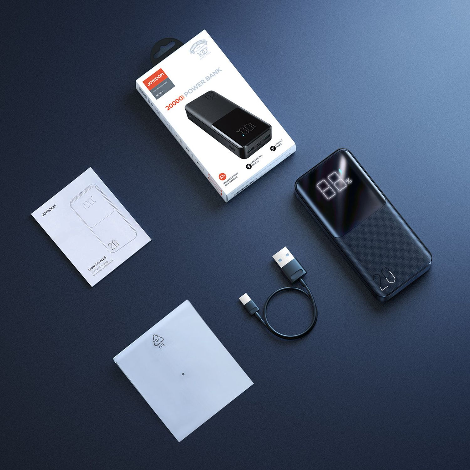 Powerbank mit Box, Kabel und Bedienungsanleitung. Die Powerbank zeigt 88% Ladung. Alle Artikel sind schwarz.