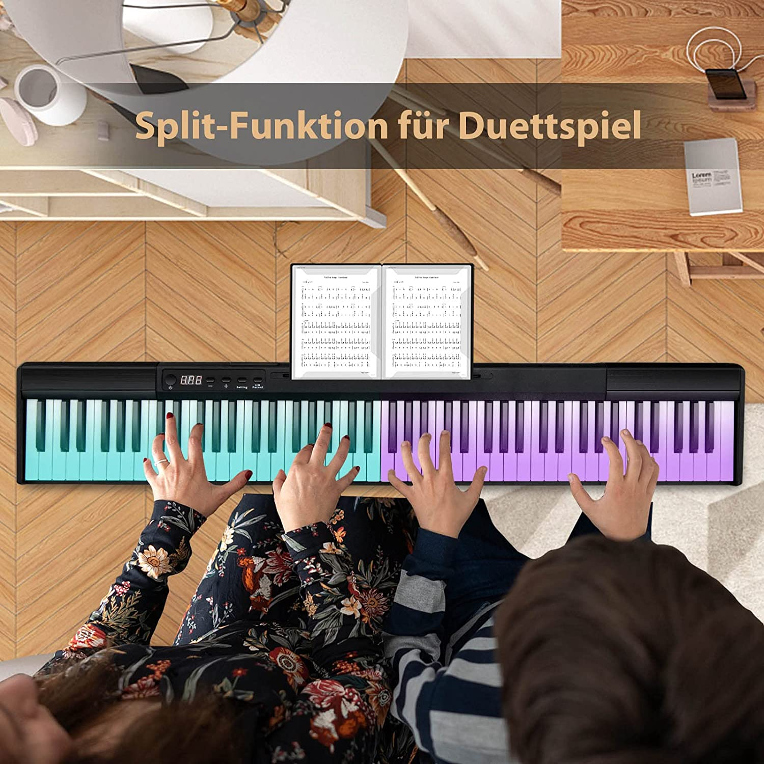 Zwei Personen spielen Klavier mit grünen und lila Tasten.