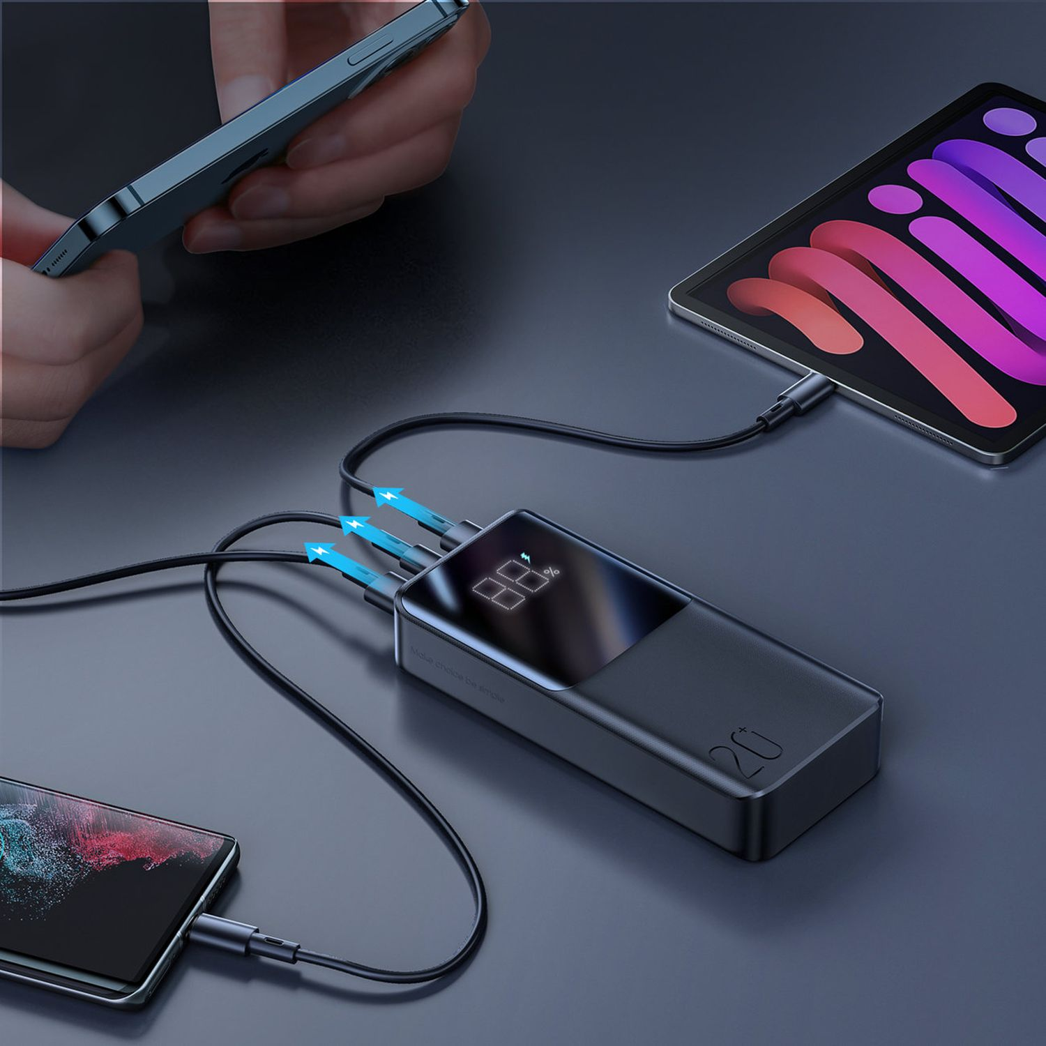 Czarny power bank ładujący telefony i tablet. Wyświetlacz pokazuje 88%. Kable z niebieskimi końcówkami.