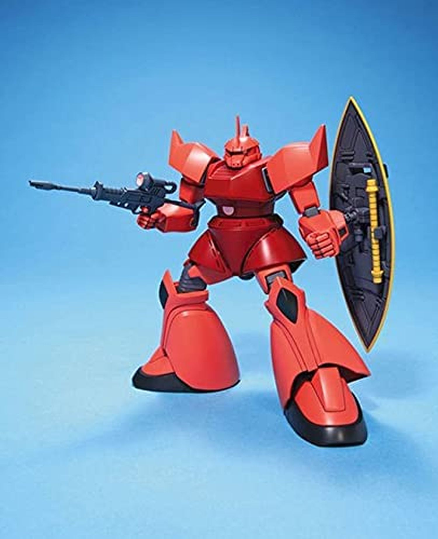 Ein rotes Roboterspielzeug, das eine Waffe und einen Schild hält. Es steht auf blauem Grund. Es hat eine schwarze Basis und ist ein Modell.