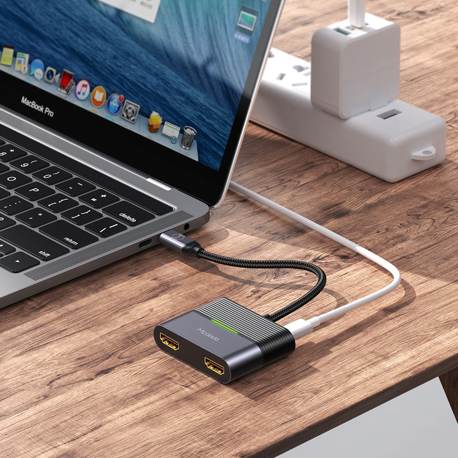 Laptop, der an einen Hub angeschlossen ist, der mit einer Steckdose und einem USB-Gerät verbunden ist.
