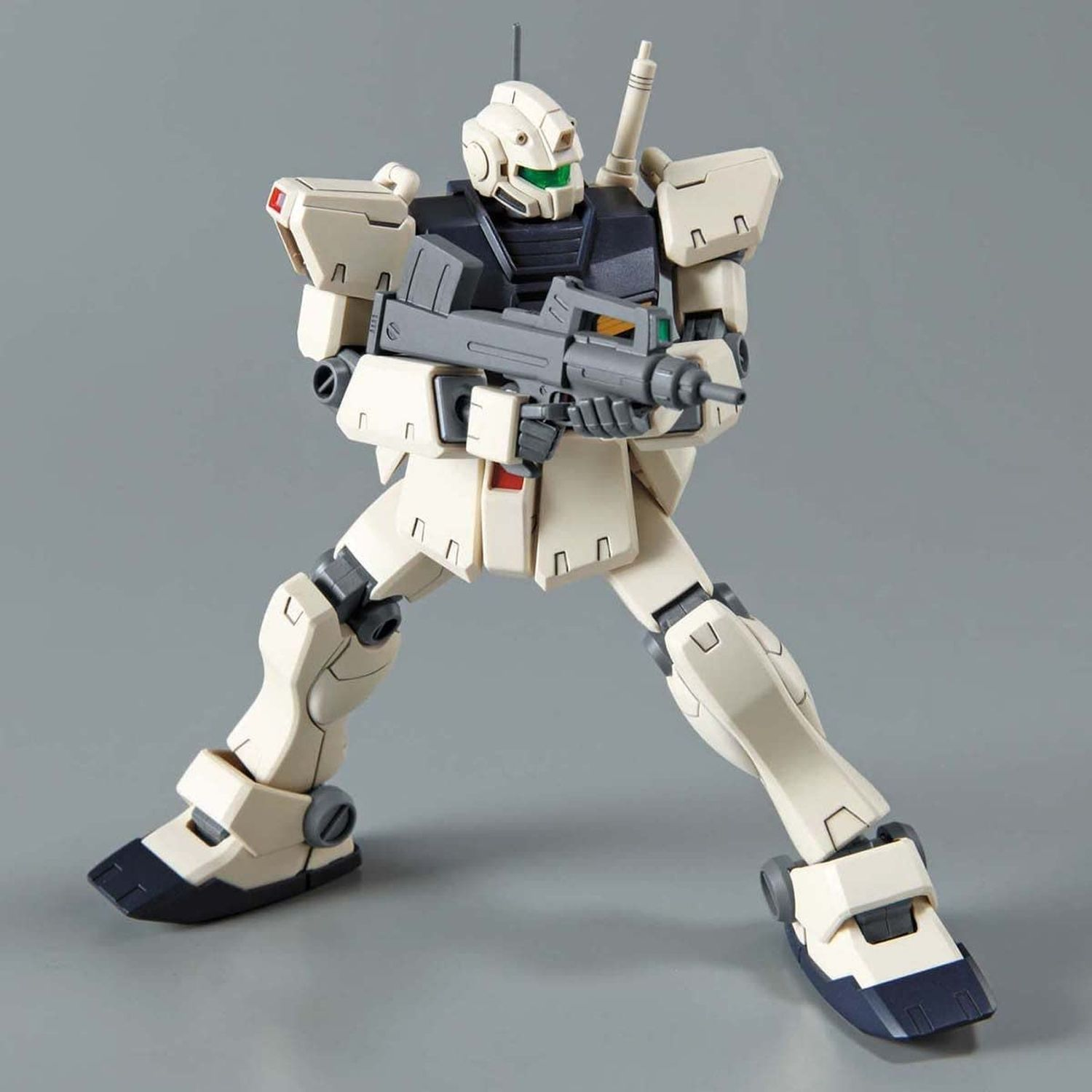 Beiges Roboterspielzeug mit grauer Waffe. Grüne Visier, Kampfpose.