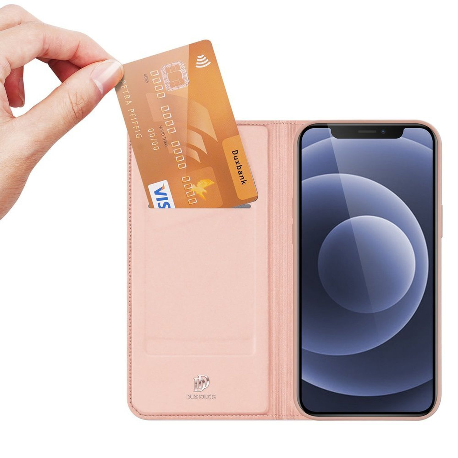Eine Hand hält eine goldene Kreditkarte und steckt sie in eine rosa Handyhülle mit Telefon.