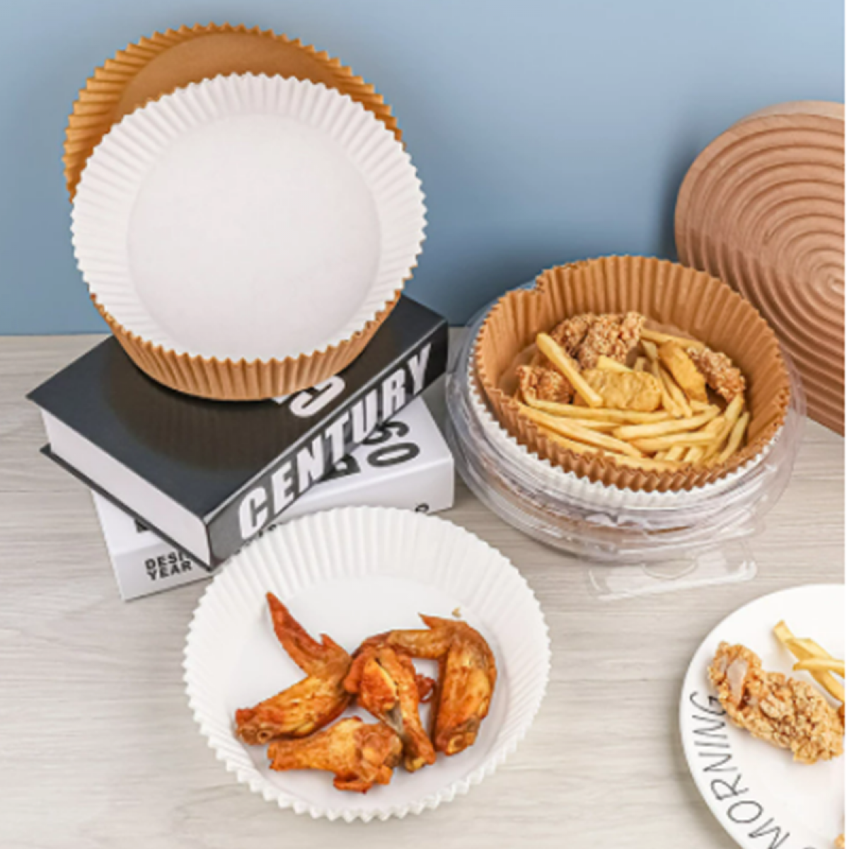 Paper food containers with food inside, on a white table. Books and a blue wall in background.