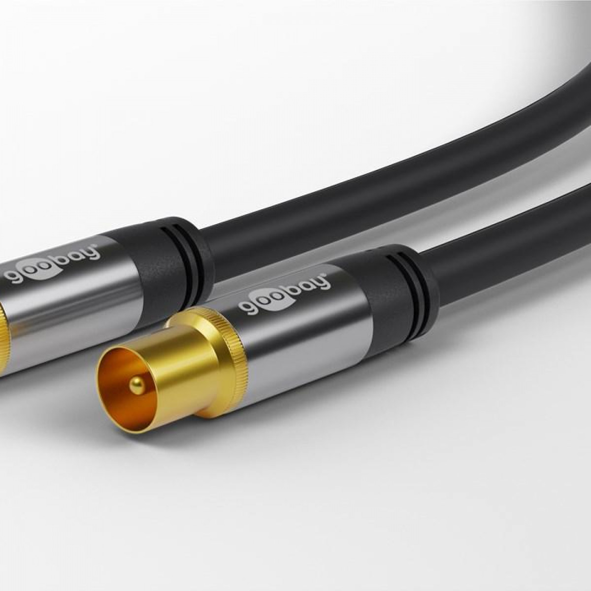 Dos cables coaxiales con conectores dorados y plateados sobre un fondo claro.