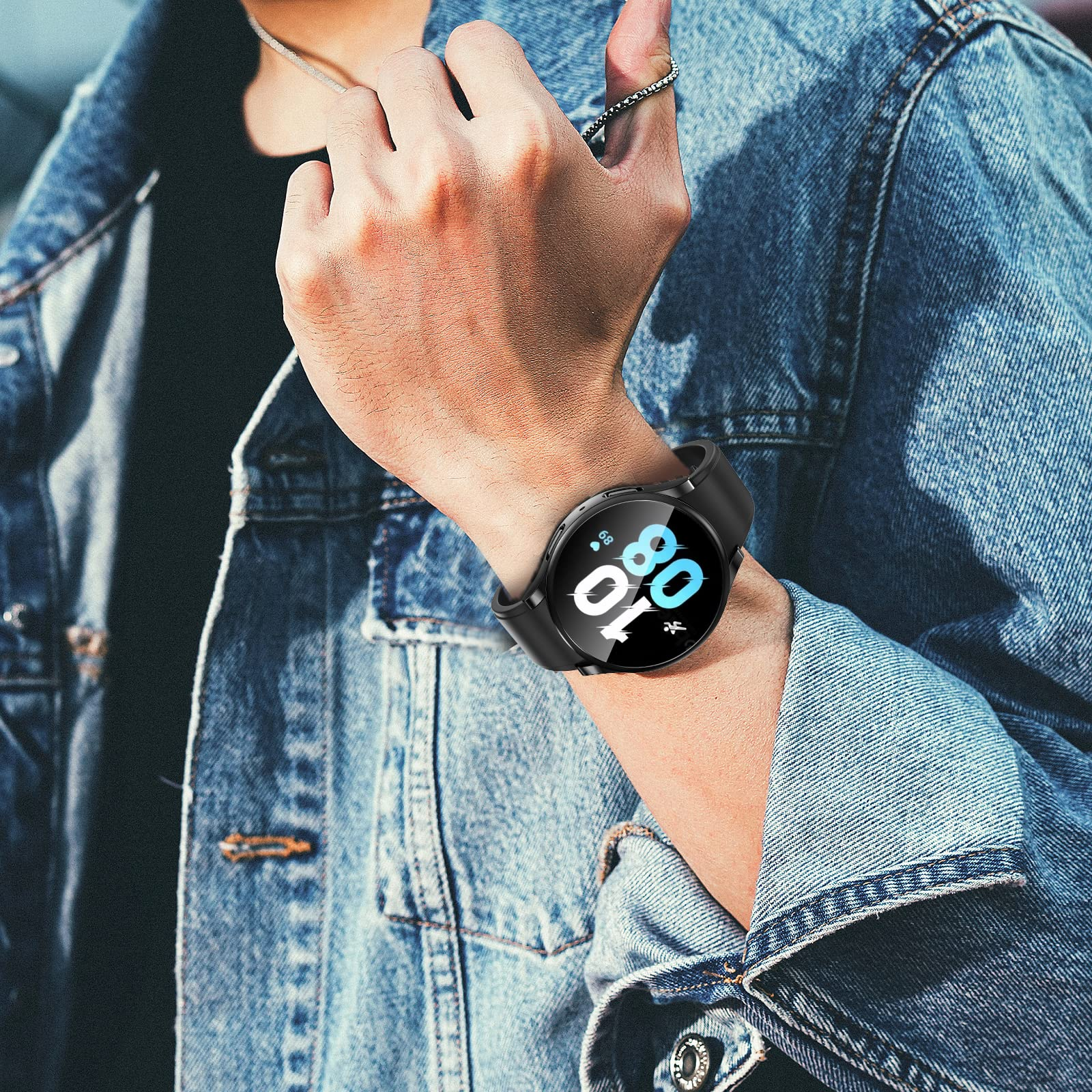 Hombre con un reloj inteligente negro, chaqueta de mezclilla. El reloj muestra una pantalla azul y blanca con hora y estadísticas.