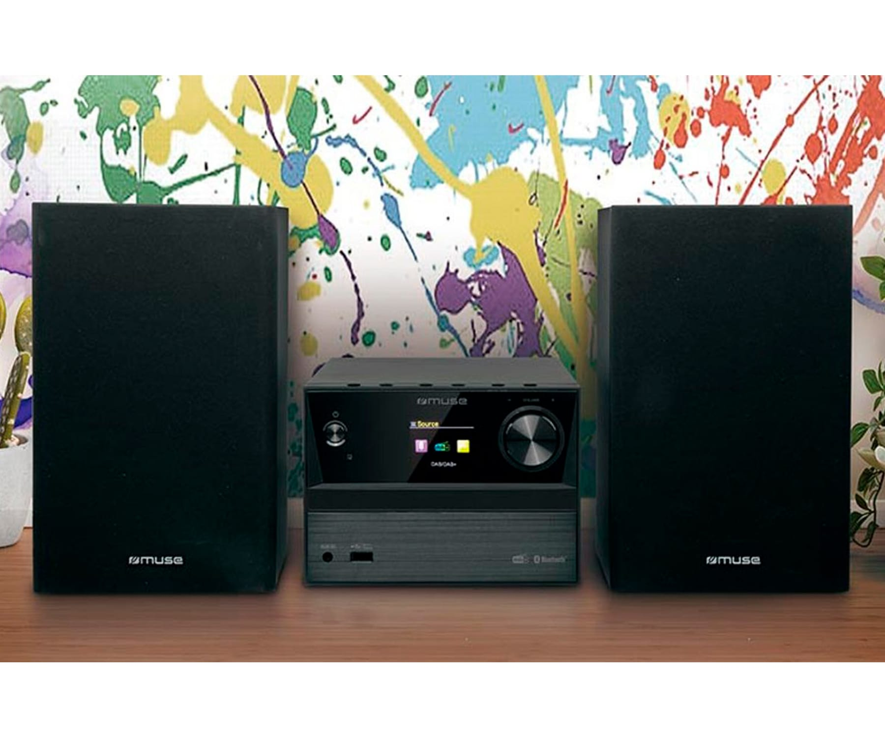 Un equipo de música con dos altavoces negros y una unidad de control negra en el medio, con un fondo colorido.